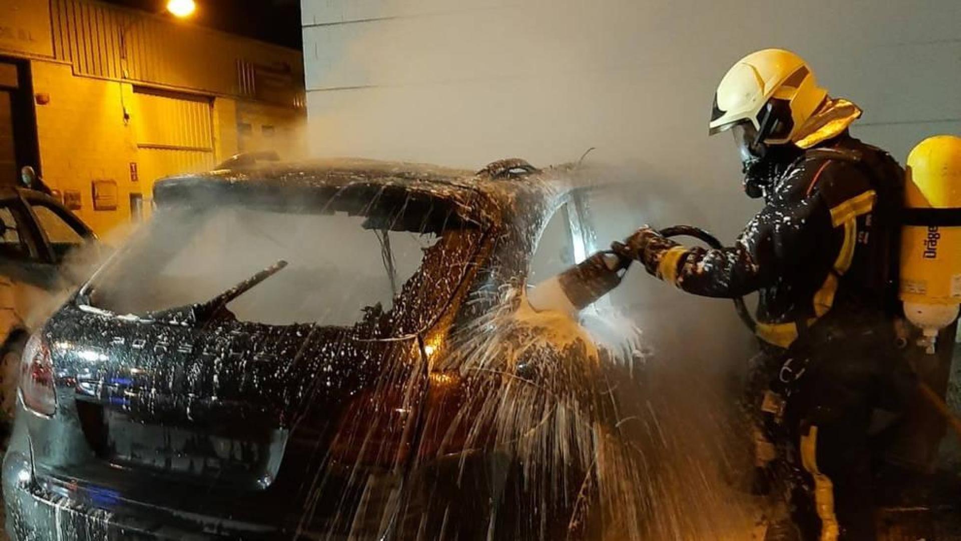 Un bombero sofoca el fuego en un vehículo en el Polígono de Mutilva.