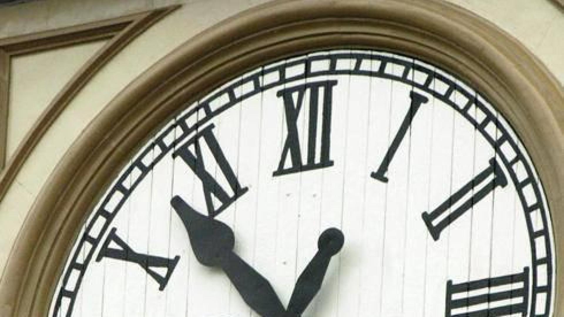 Un operario cambiando la hora de un reloj.
