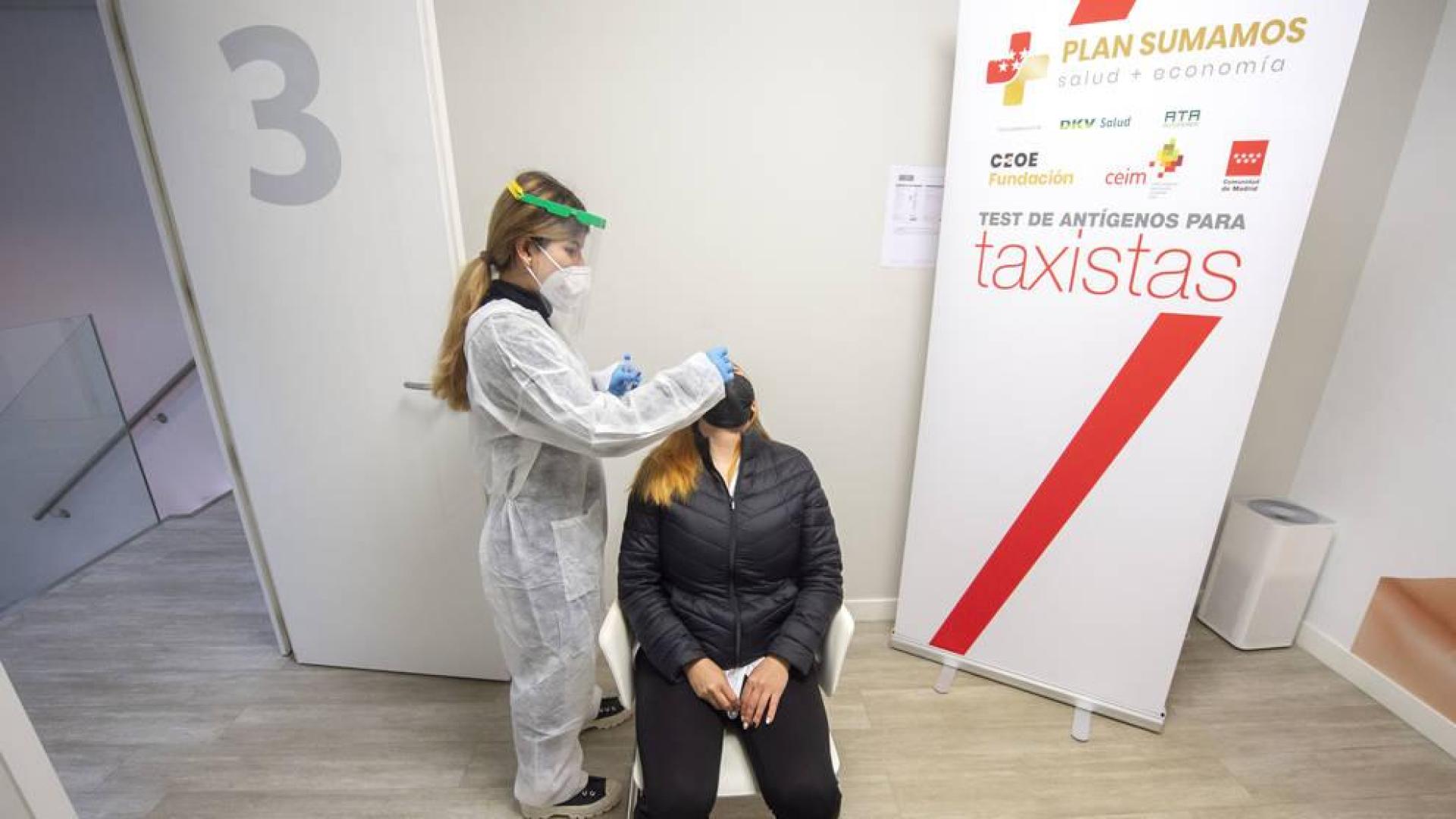 Una trabajadora sanitaria realiza un test de antígenos a una taxista de la Comunidad de Madrid.