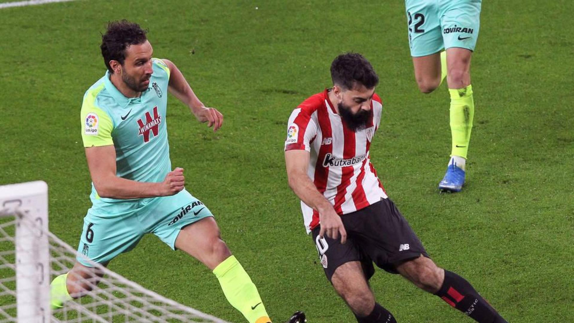 El delantero del Athletic, Asier Villalibre, se dispone a golpear el balón ante el defensa del Granada, Germán Sánchez.