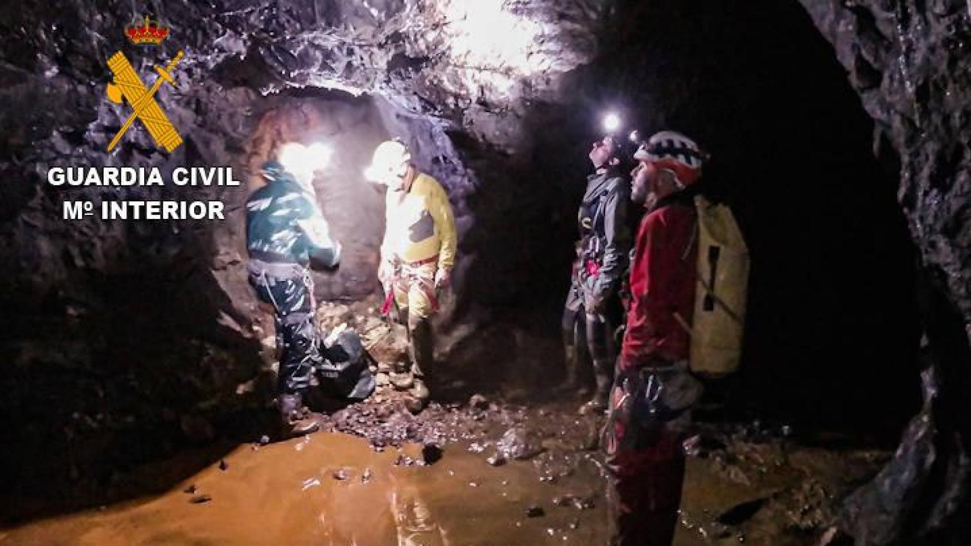 Guardia Civil y los espeleólogos, junto a la bolsa de explosivos en el interior de la cueva.