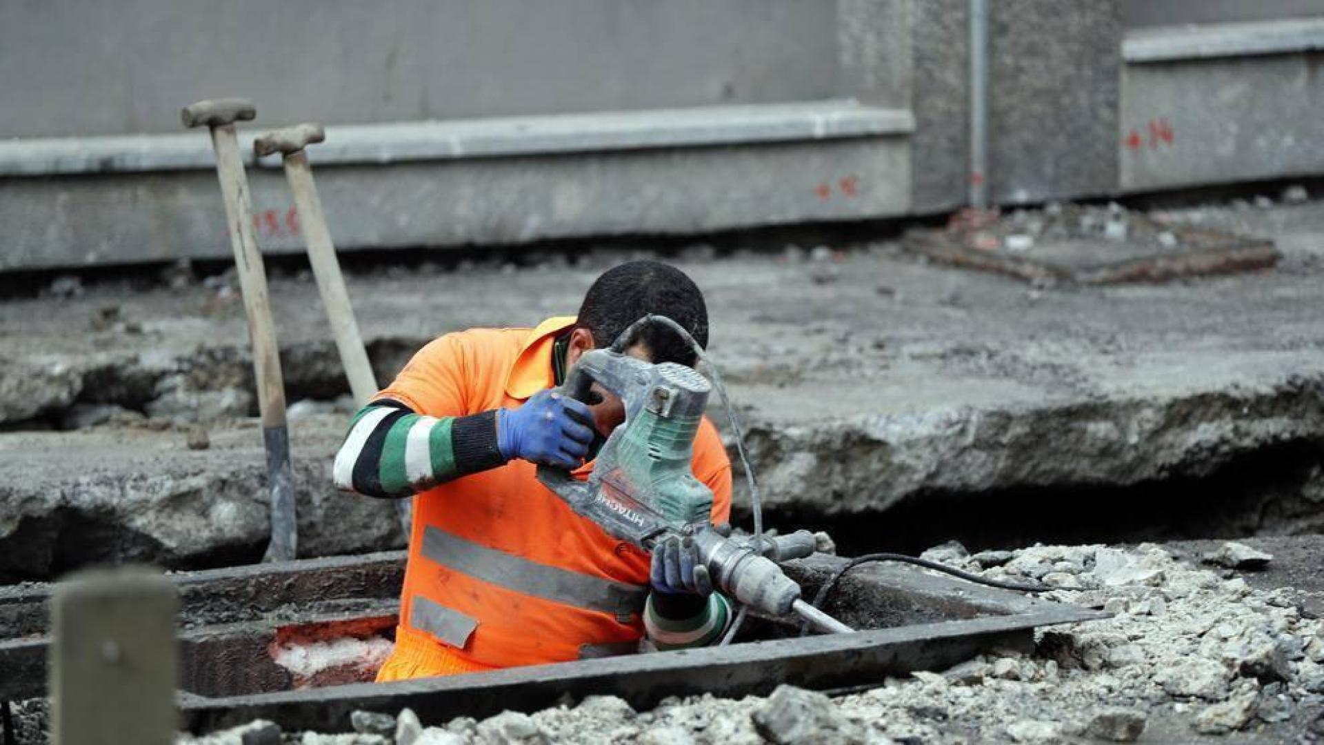 Un trabajador realiza obras en el asfalto de una calle.