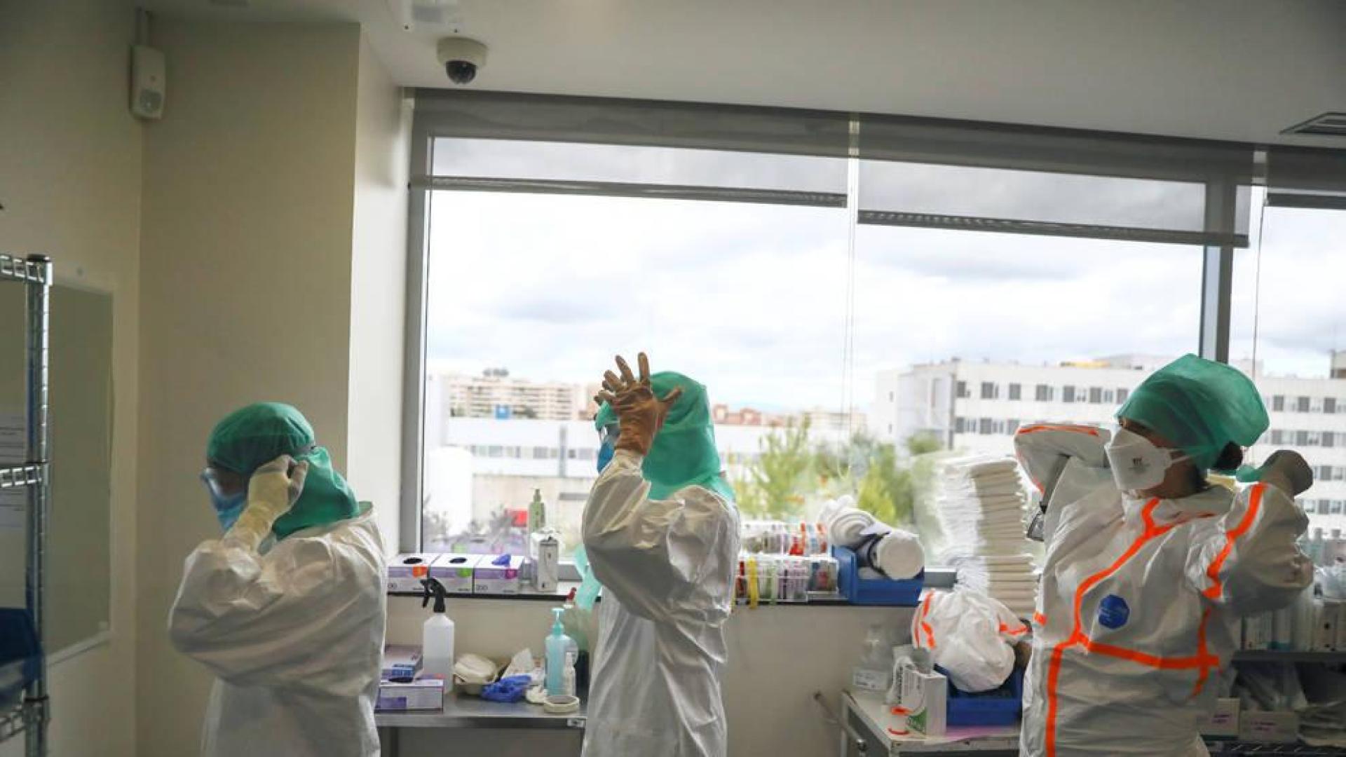 Profesionales médicos se preparan antes de entrar a la UCI en el Hospital de La Paz de Madrid.