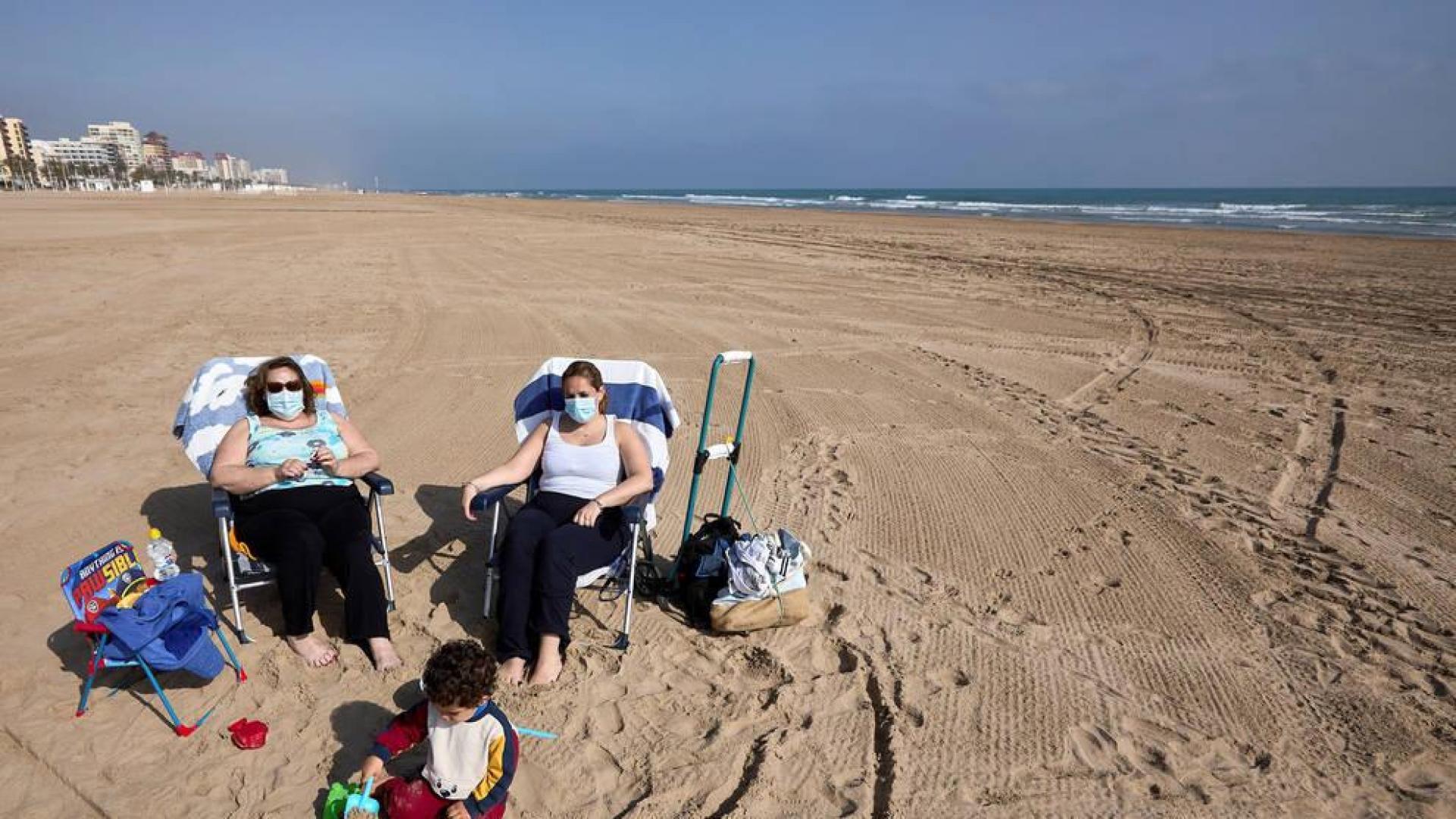 Varias personas toman el sol en la playa de Gandía.