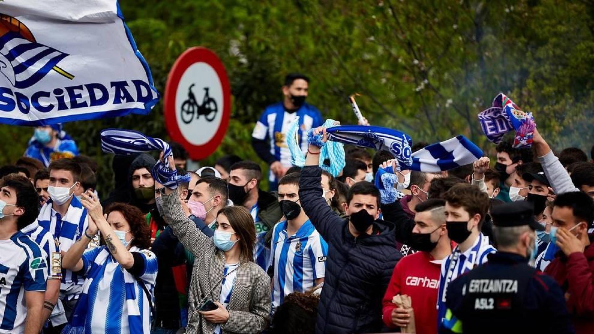 Cientos de aficionados de la Real Sociedad han aguardado en los márgenes de la carretera que conecta el aeropuerto de Hondarribia con San Sebastián para saludar a los campeones de la Copa del Rey.
