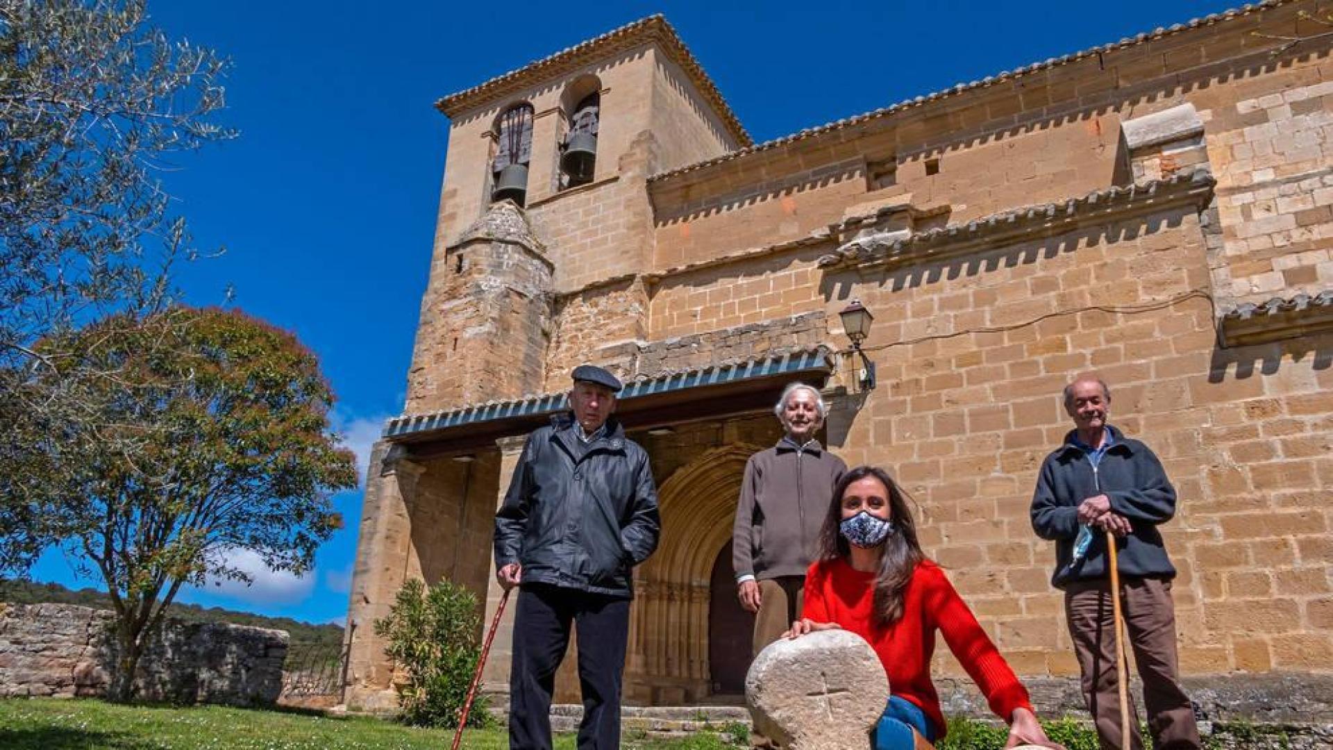 Felipe Oroquieta Villar,  José María Lander Azcona y José Luis Martínez Díaz junto a la iglesia de Eraul. Delante, la presidenta del concejo, Irantzu Lizarraga López, muestra dos de las estelas.