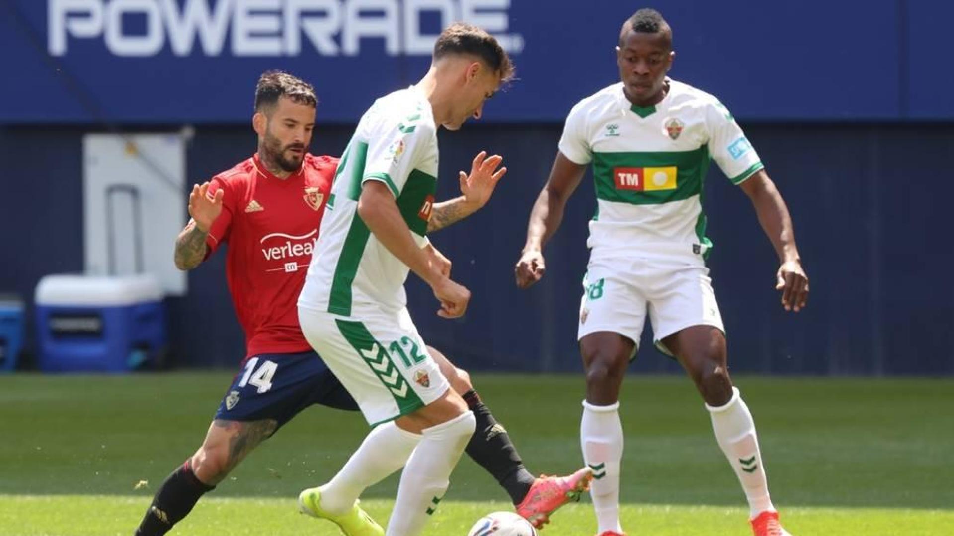 Rubén García pelea por un balón con dos rivales del Elche.