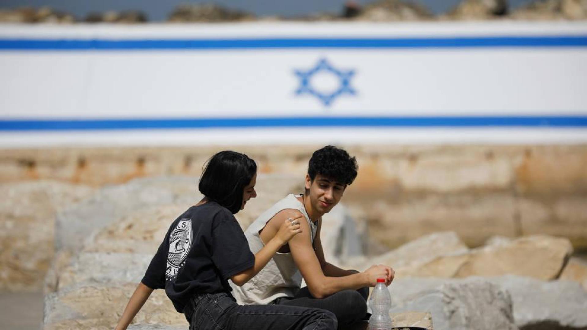 Dos ciudadanos israelíes disfrutan de poder estar al aire libre sin mascarilla.