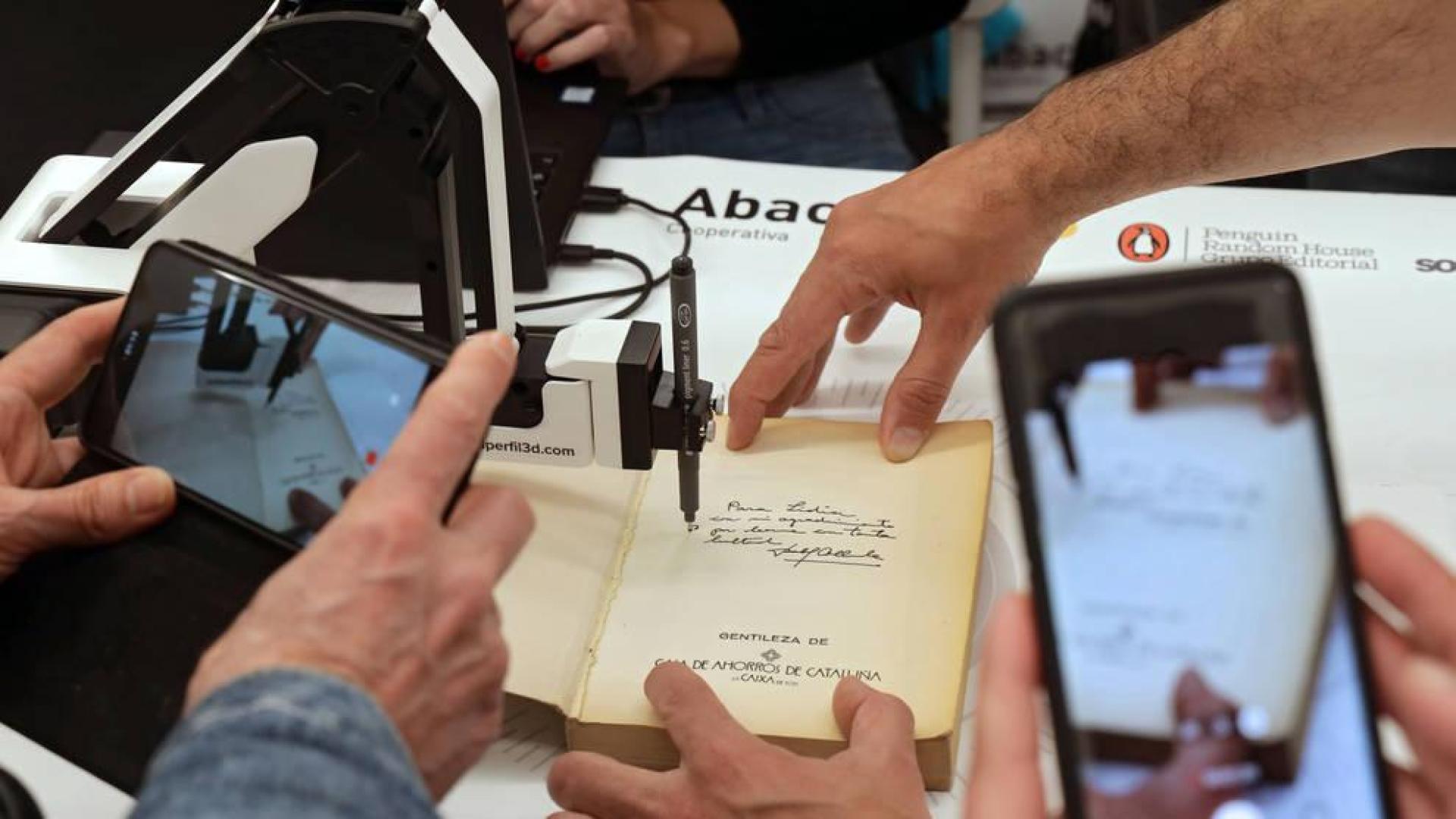 Firma de un libro con un brazo robótico en el Espai Abacus