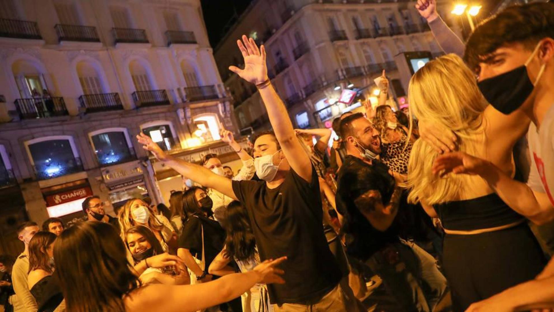 Jóvenes en Madrid celebran el final del toque de queda en la Puerta del Sol.
