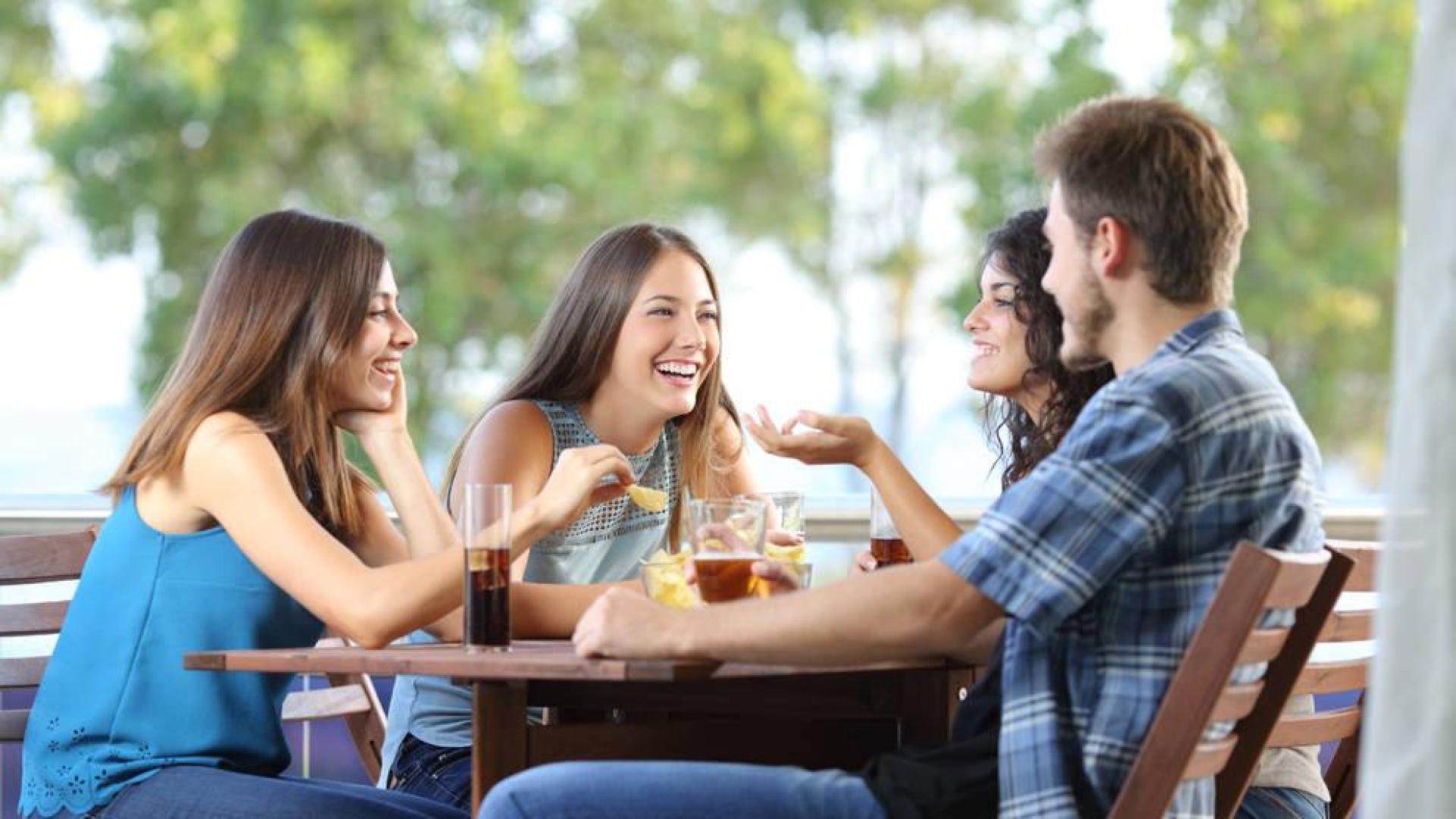 Un grupo de amigos toma un refresco en una terraza