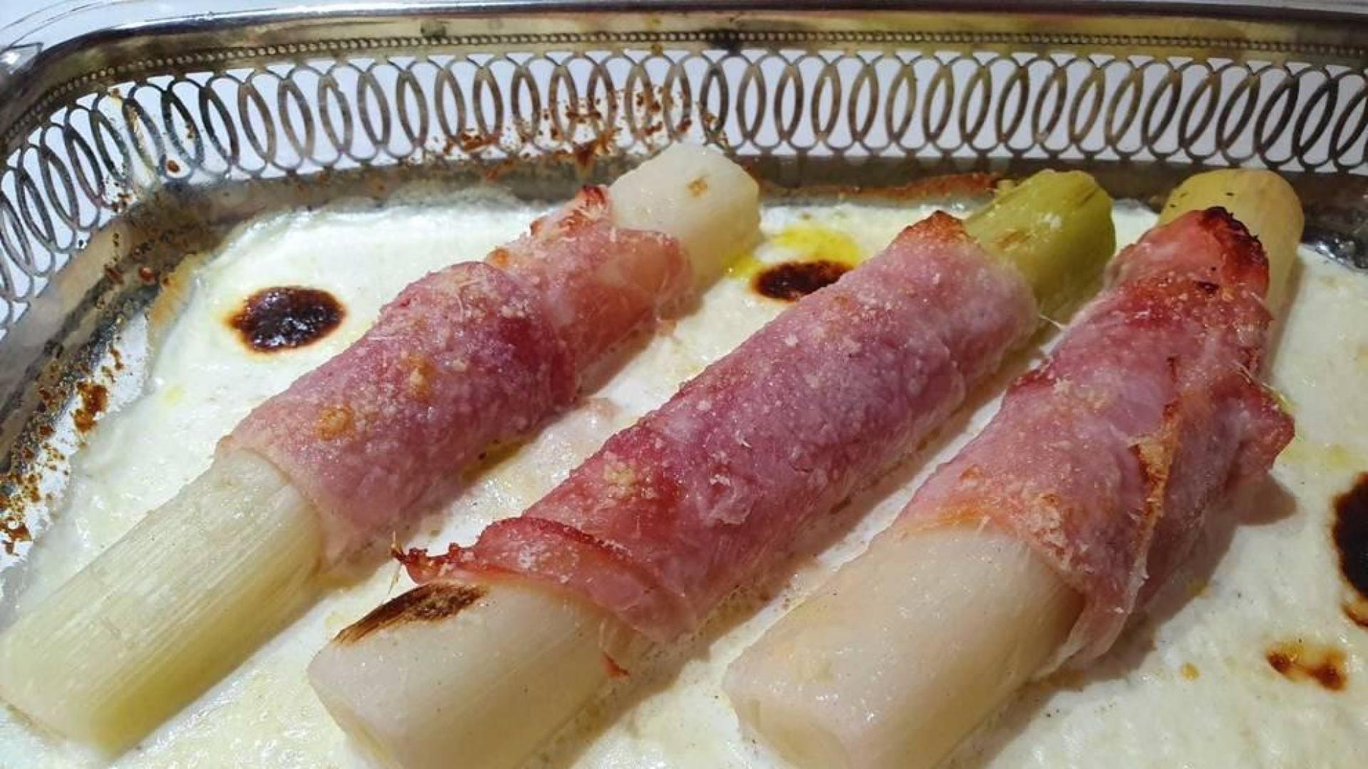 Puerros envueltos en jamón con salsa de nata y comino