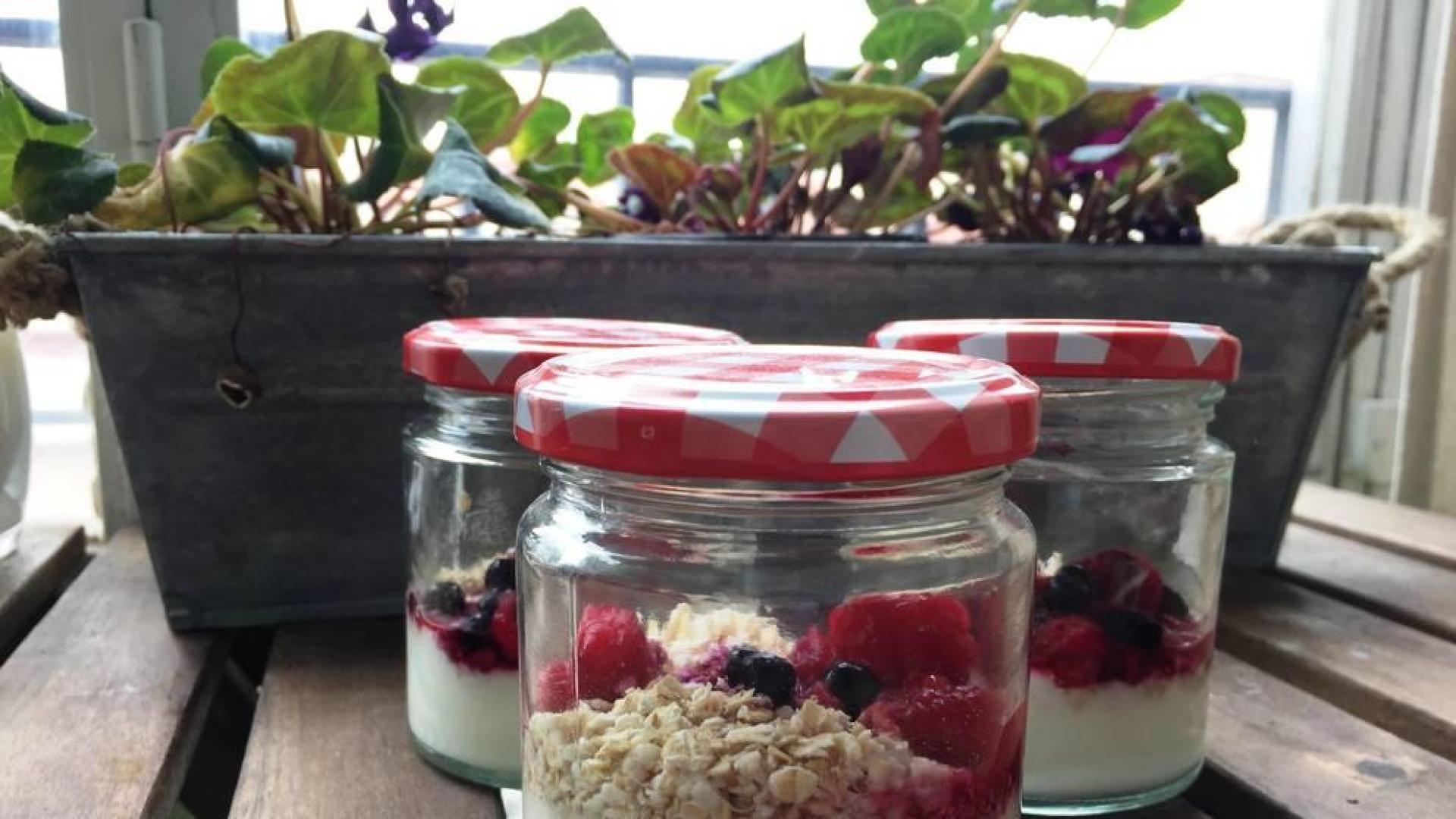 Imagen de los yogures con los frutos del bosque presentados bonitos.
