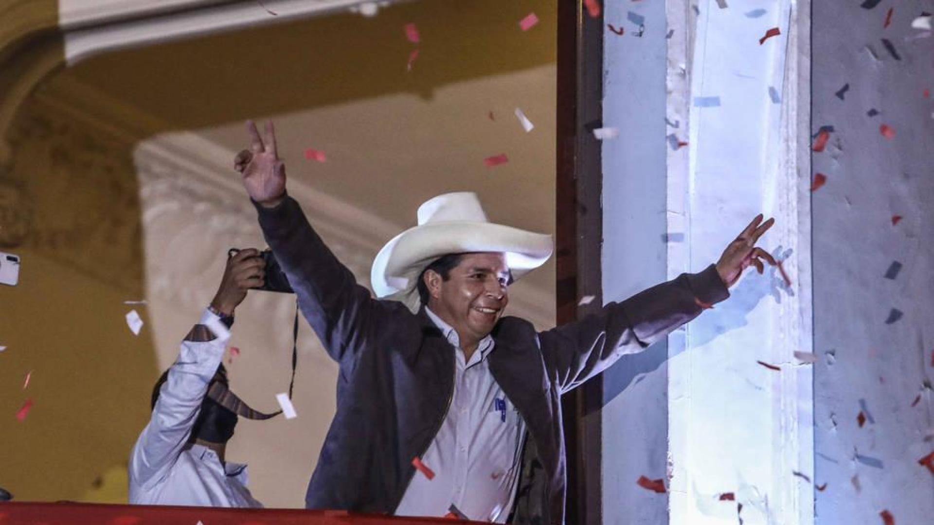 El candidato presidencial peruano Pedro Castillo saluda a sus seguidores en el balcón de la sede central de su partido, en Lima.