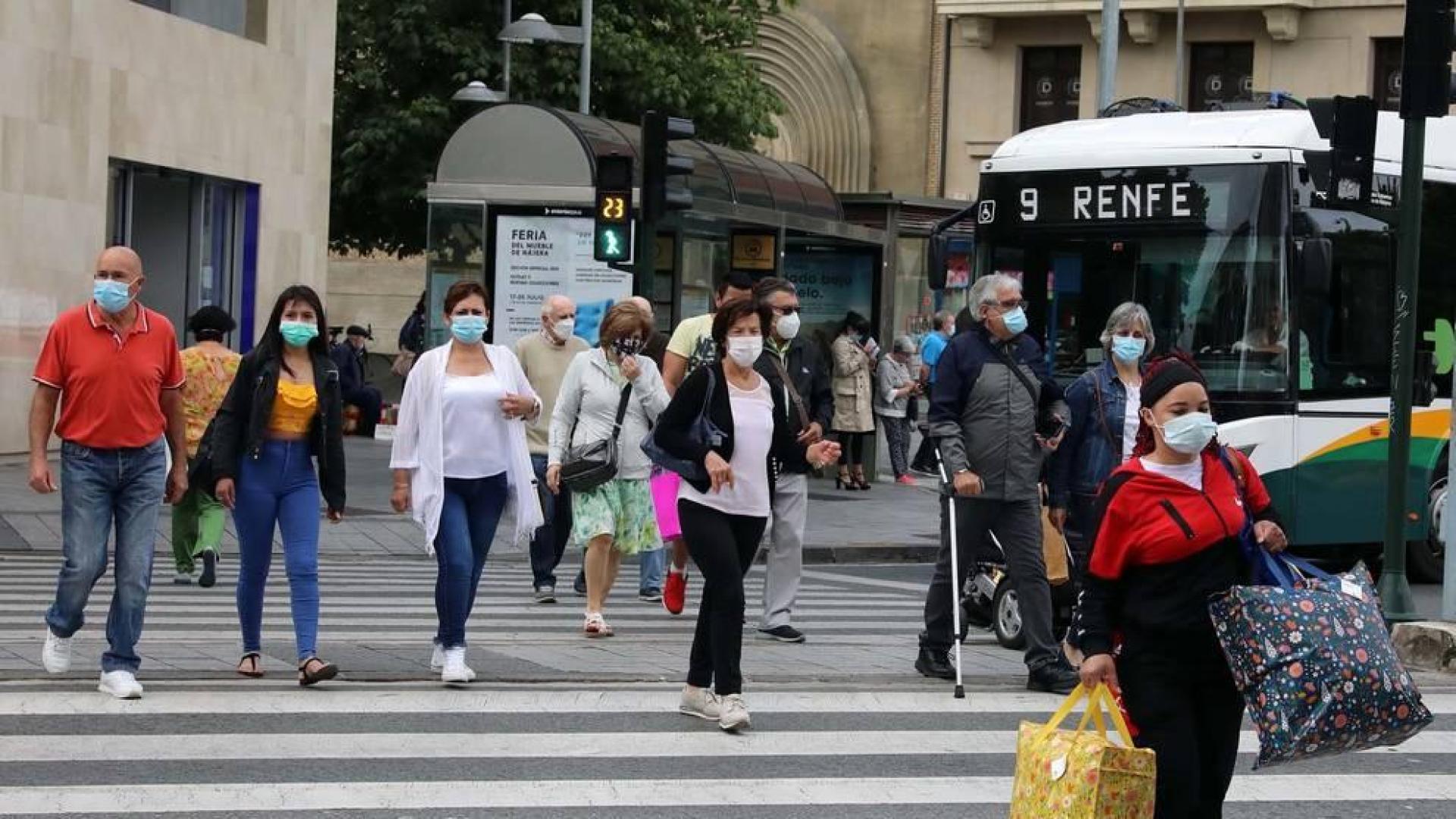 Varias personas, con mascarillas, por las calles de Pamplona.