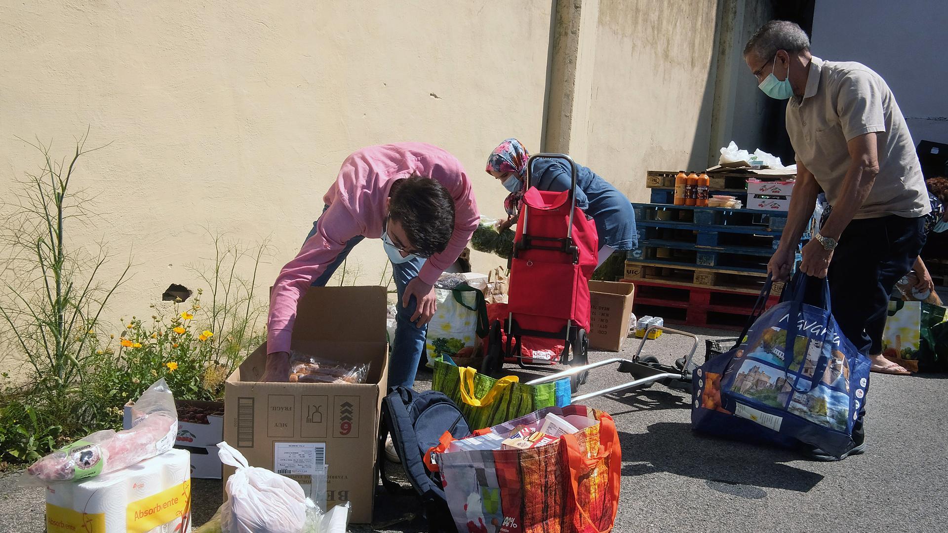 Una vez que reciben las cajas de alimentos, se separan de la fila y organizan la comida