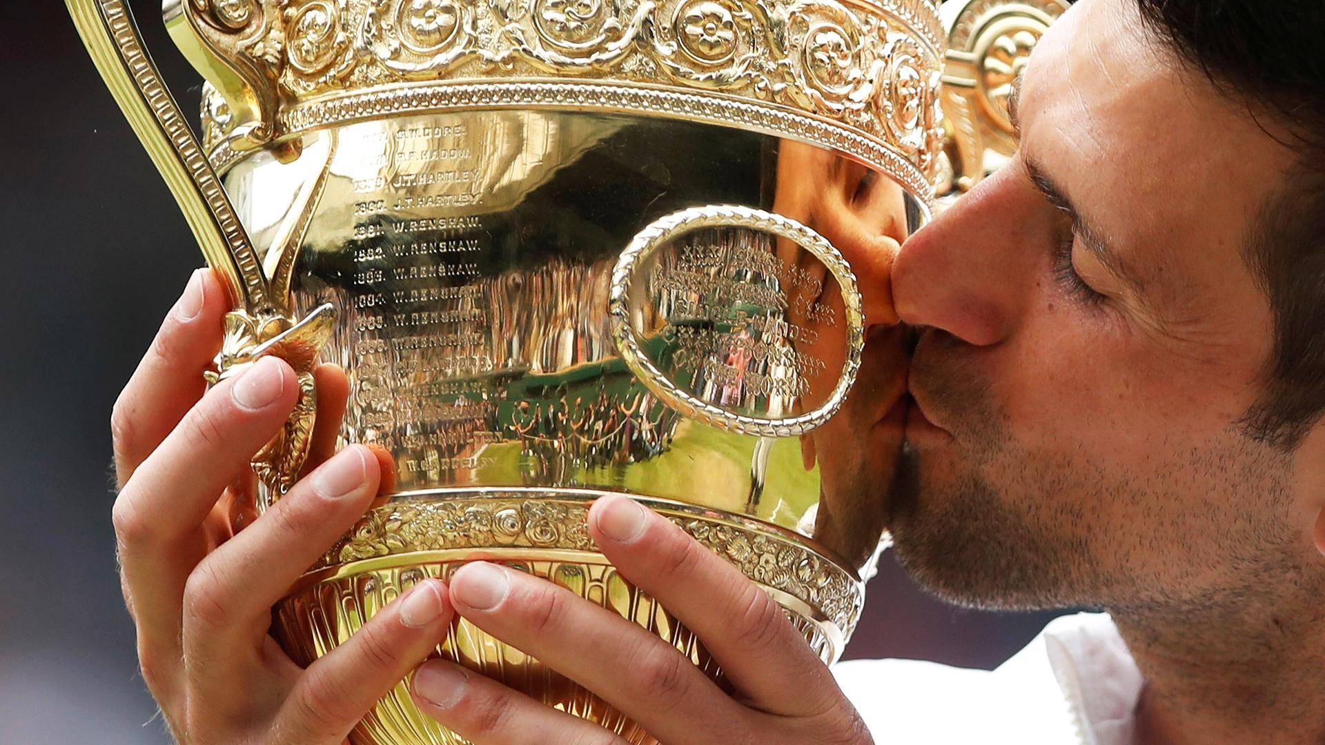 Novak Djokovic besa el trofeo que le acredita como vencedor de Wimbledon 2021