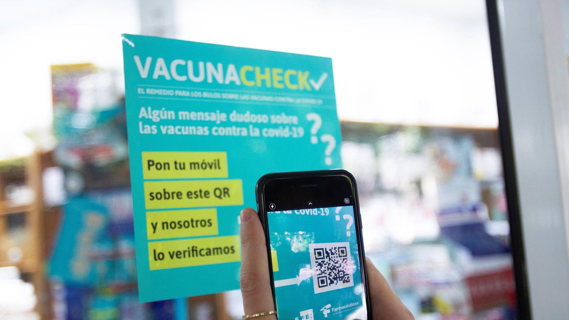 Una persona escanea con su teléfono el código QR de una farmacia para obtener información