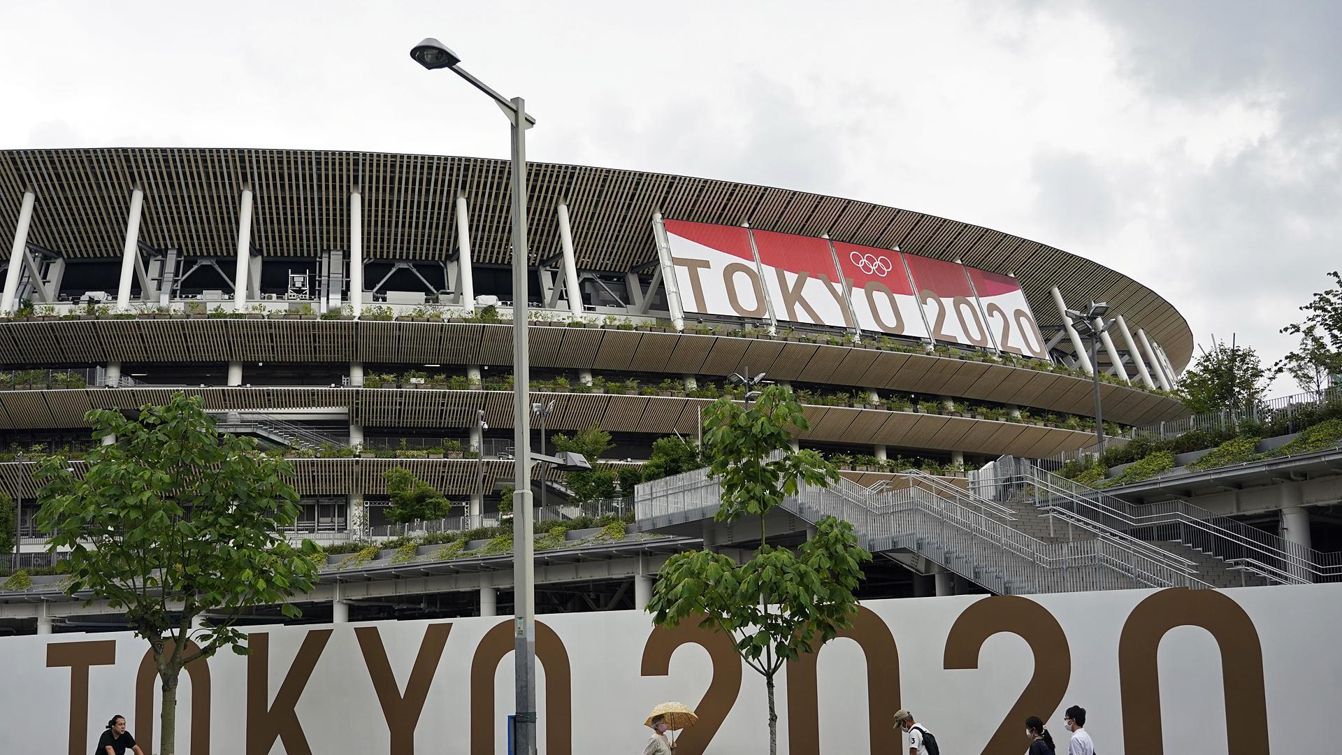 Varias personas pasan delante del Estadio Nacional de Tokio
