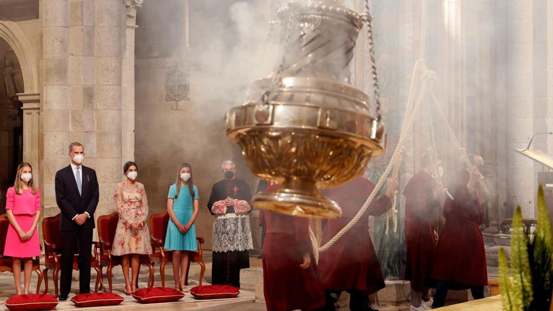 Los reyes Felipe VI (2i) y Letizia, junto a sus hijas Leonor (i), princesa de Asturias, y la infanta Sofía (4i), observan a los "tiraboleiros" (d) controlar el movimiento del Botafumeiro durante la ofrenda al Apóstol Santiago