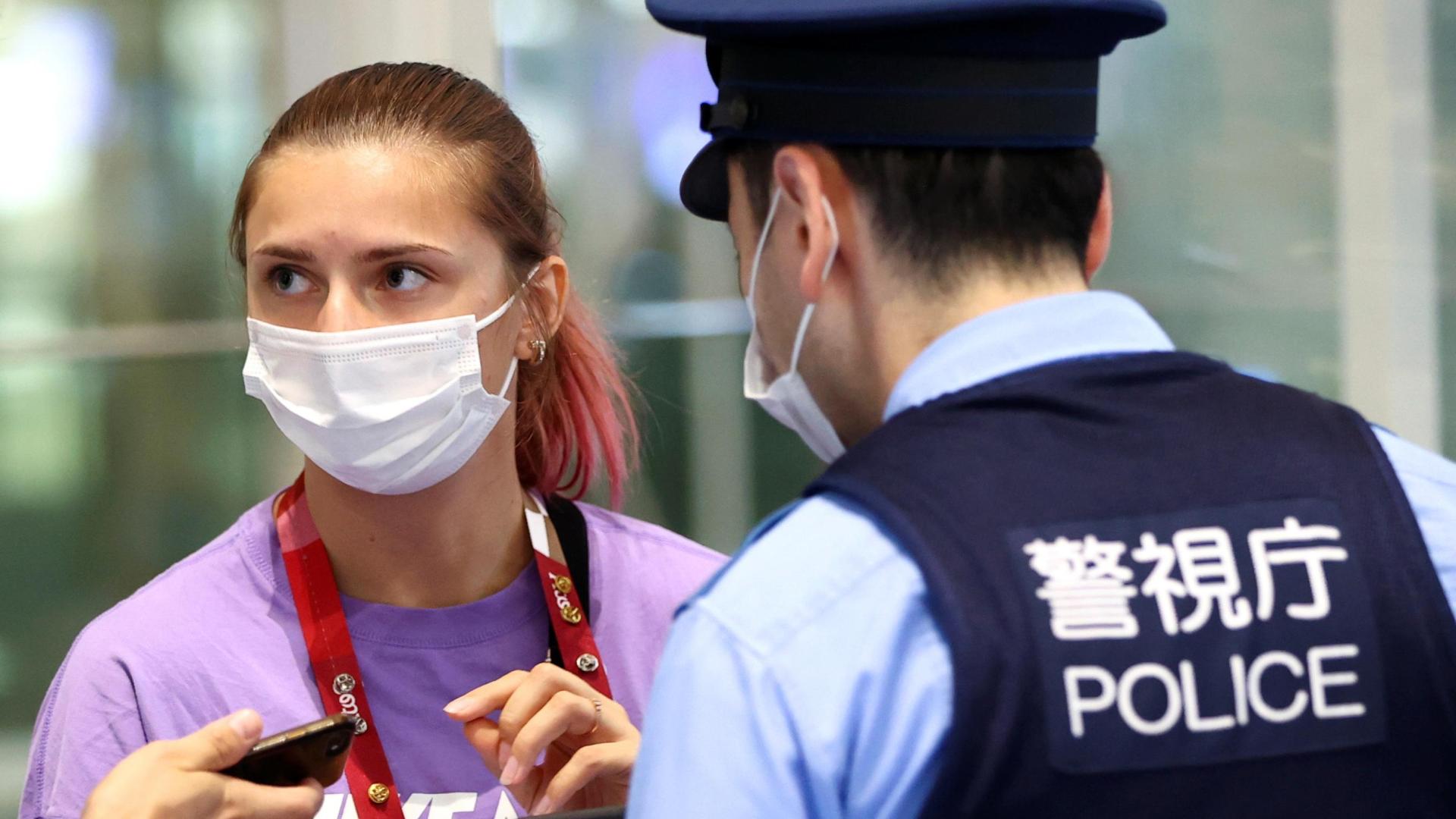 La velocista bielorrusa Krystsina Tsimanouskaya habla con varios agentes de policía en el aeropuerto de Tokio