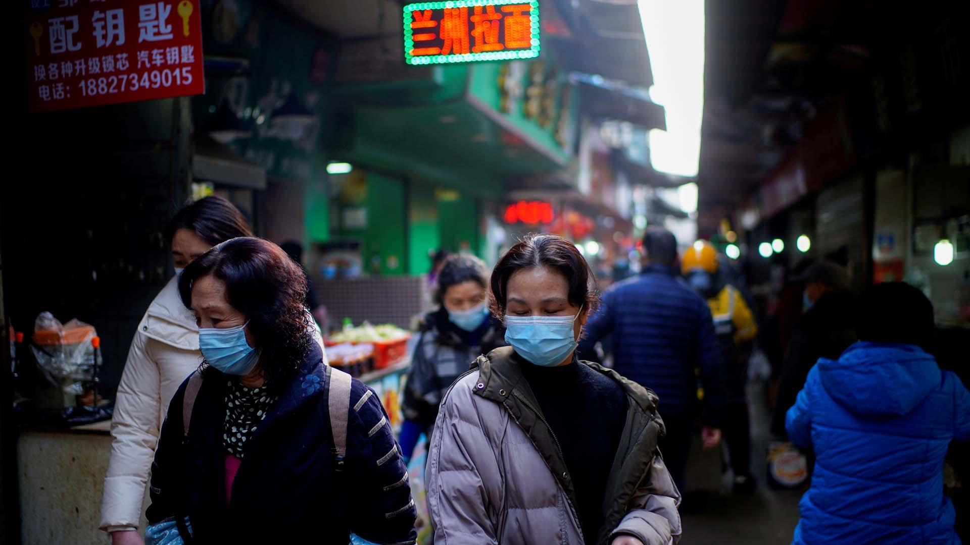 Varias personas caminan por las calles de Wuhan