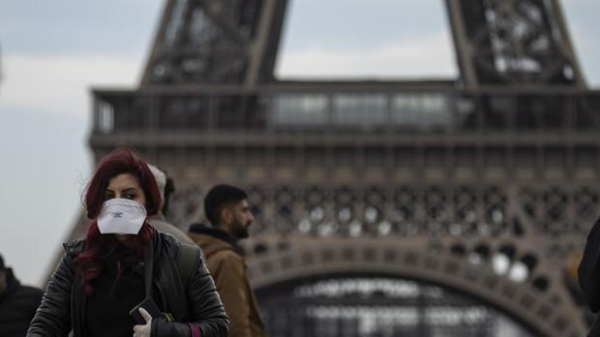 Una mujer pasea en París protegida con una mascarilla