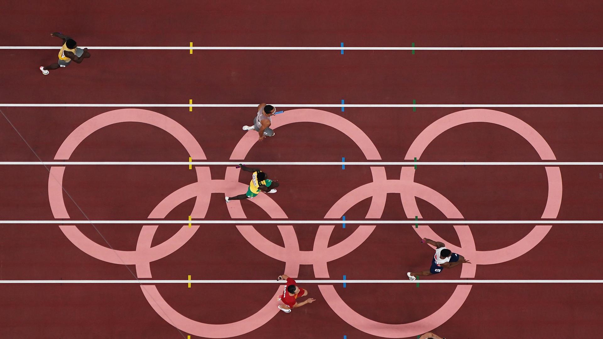 Imagen aérea de la final de 4x100 relevos con el emblema olímpico en la recta final