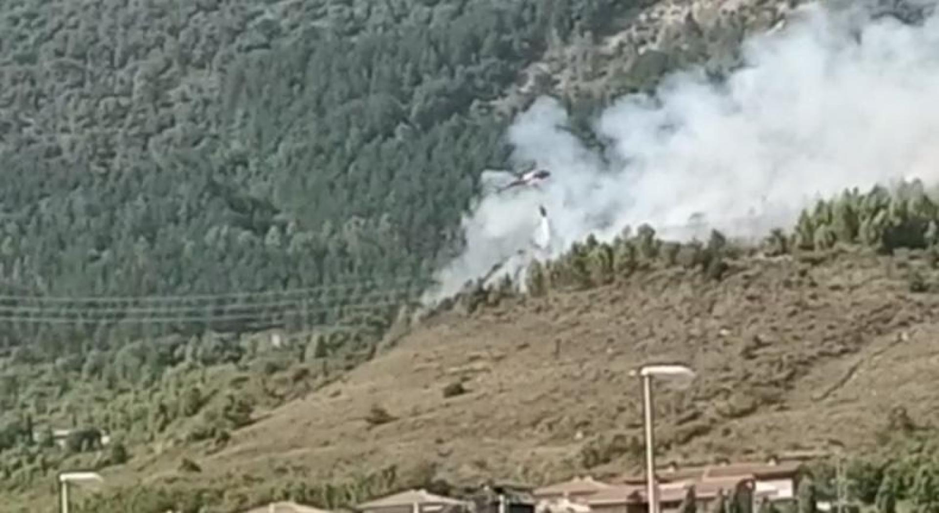 Un helicóptero lanza agua sobre las llamas del incendio del monte Ezcaba
