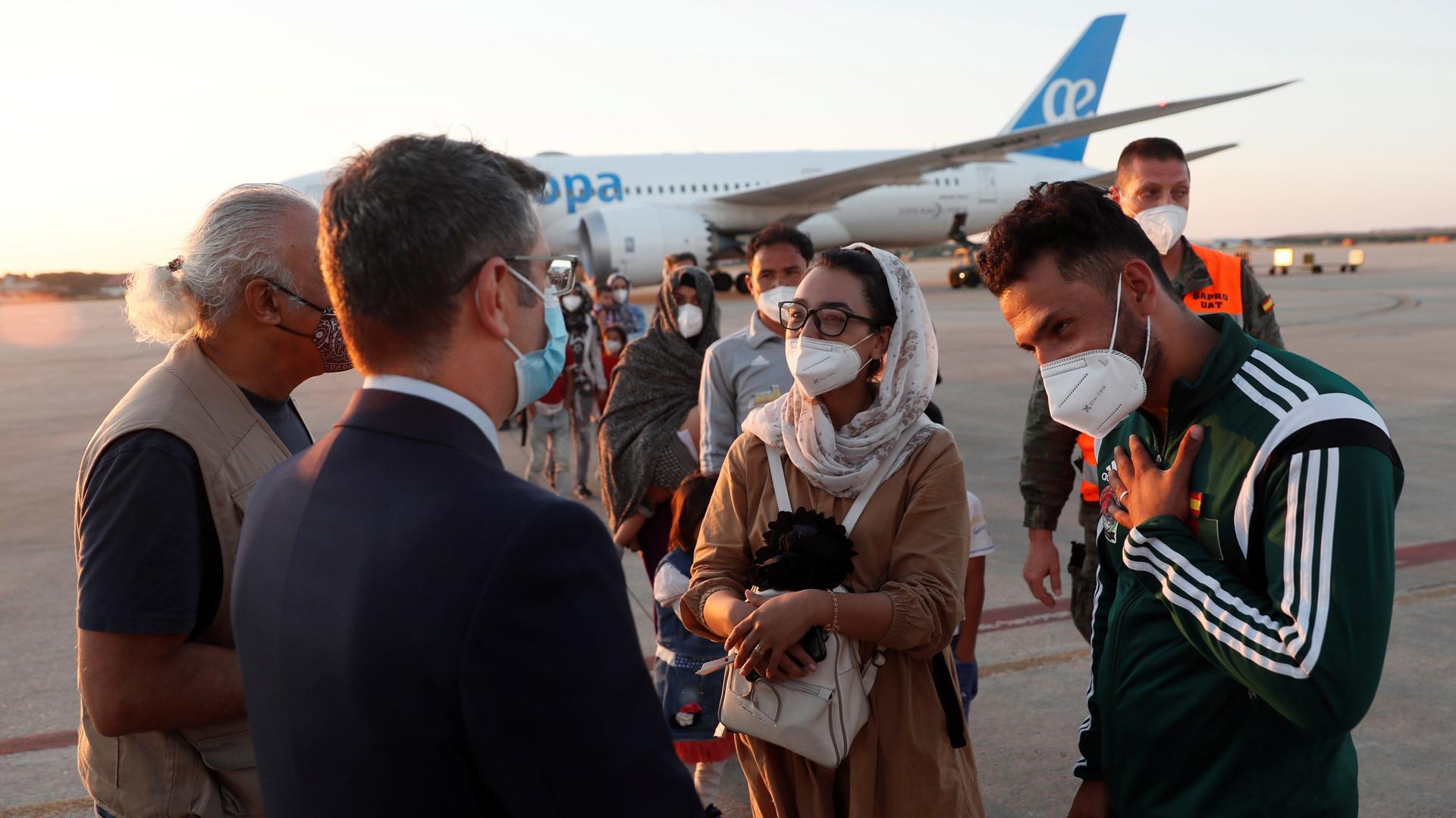 El ministro de la Presidencia, Félix Bolaños, da la bienvenida a la jugadora afgana de baloncesto en silla de ruedas Nilofar Bayat y a su marido a su llegada a la base aérea militar de Torrejón de Ardoz