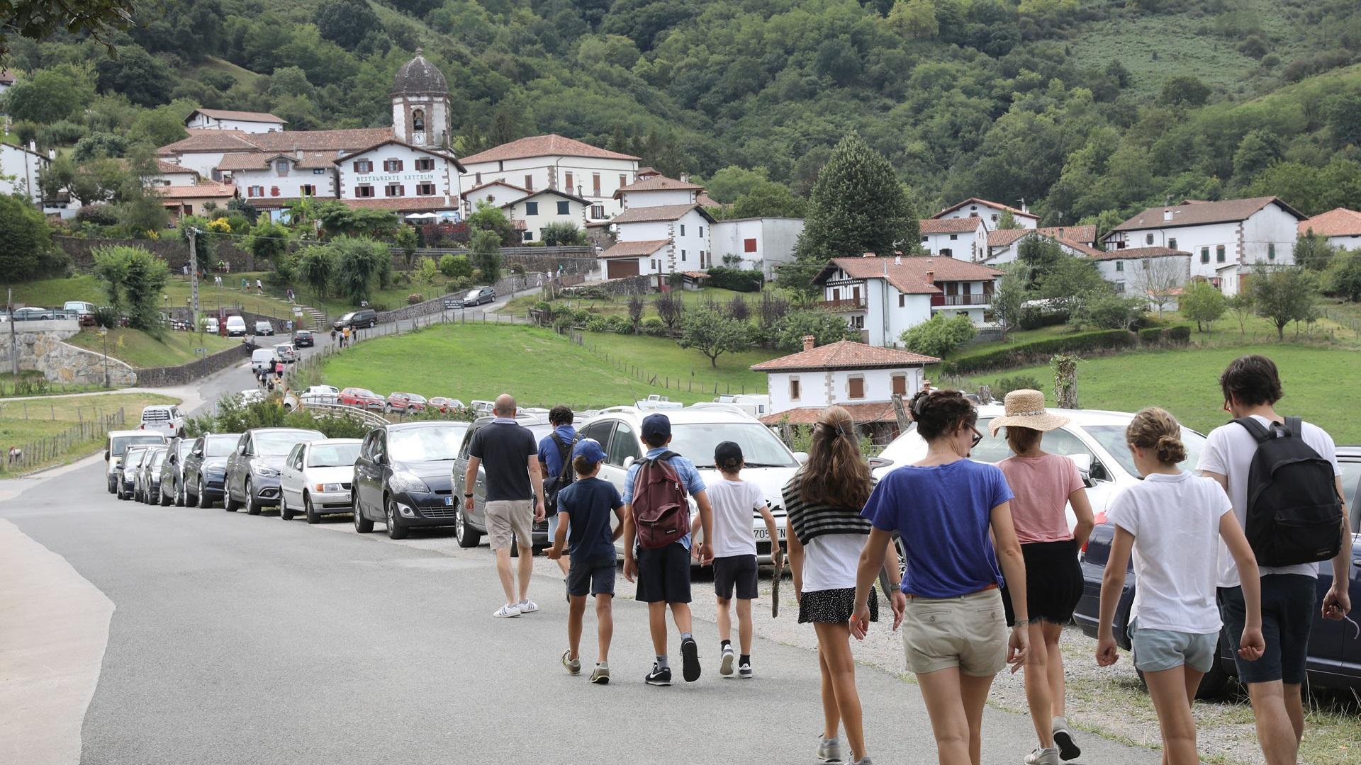 Un grupo de turistas se dirige a pie al centro urbano de Zugarramurdi