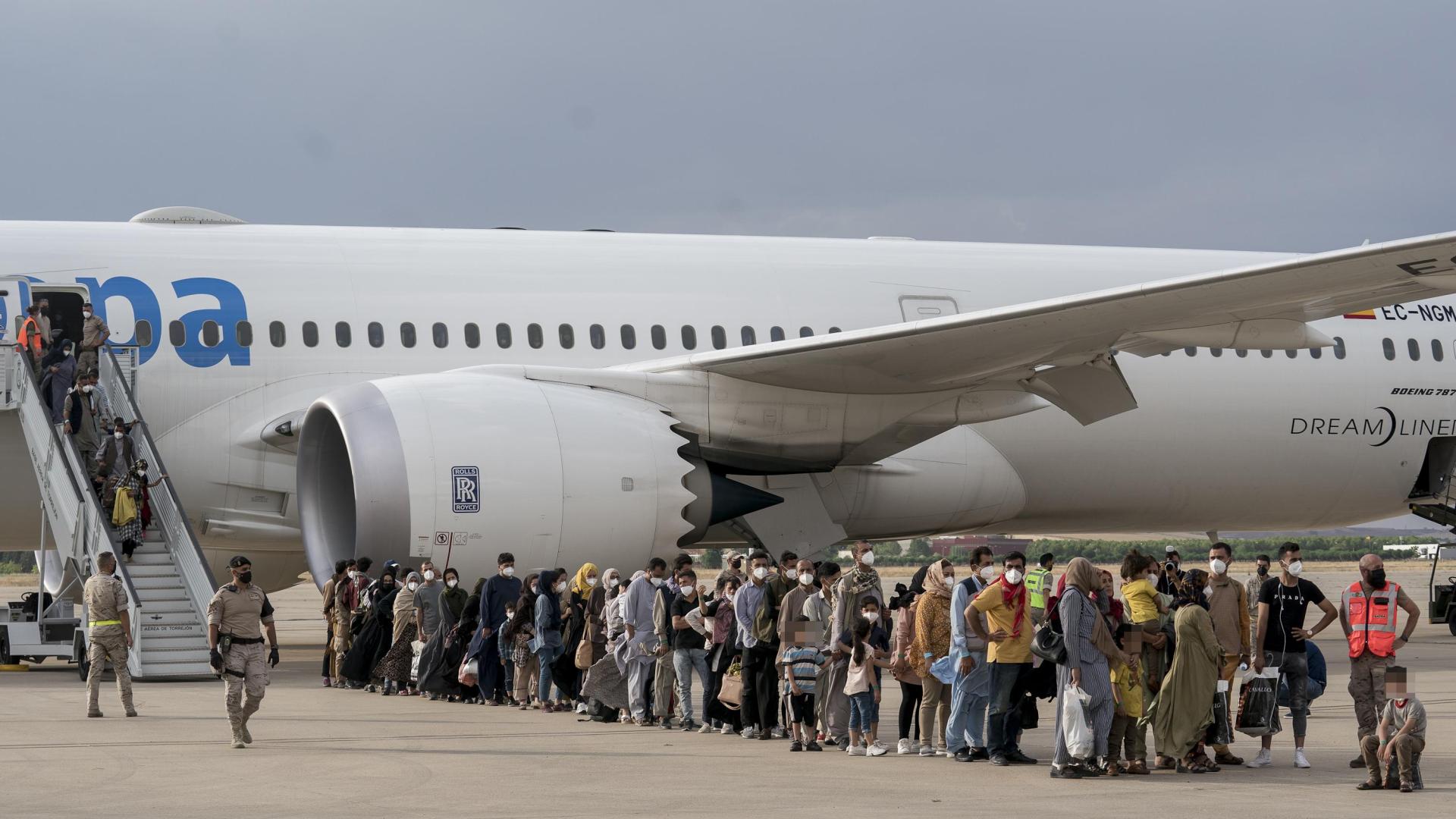 Varios refugiados tras la llegada de un nuevo avión a Torrejón