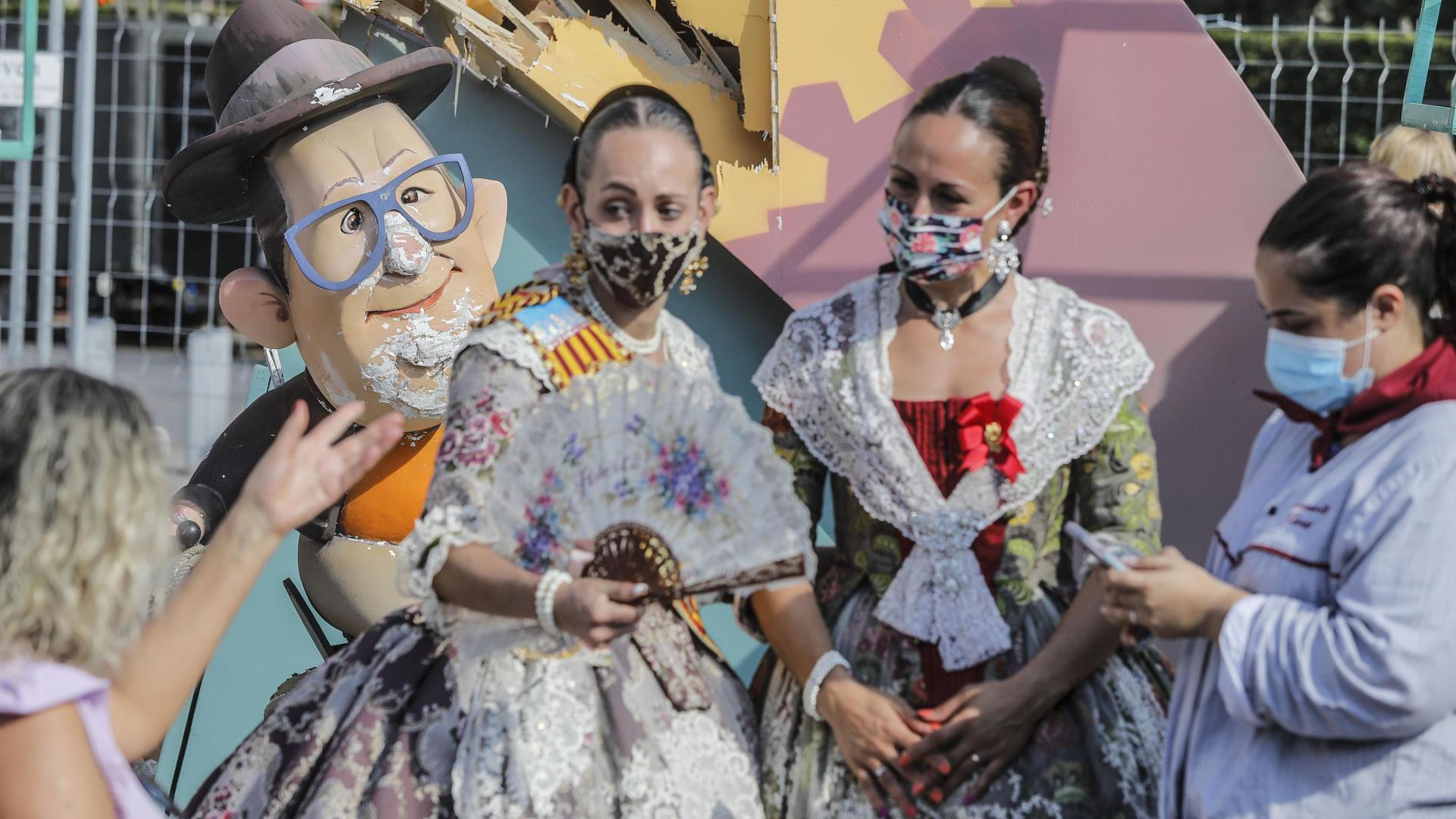 Varias falleras al lado de las fallas afectadas por las fuertes lluvias