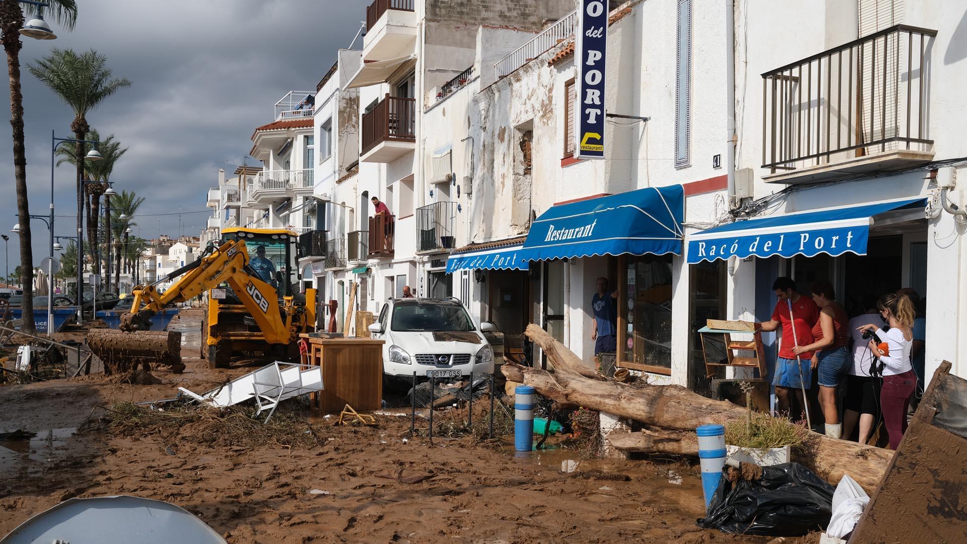 Una máquina excavadora realiza labores de limpieza en las calles inundadas en Alcanar (Tarragona)