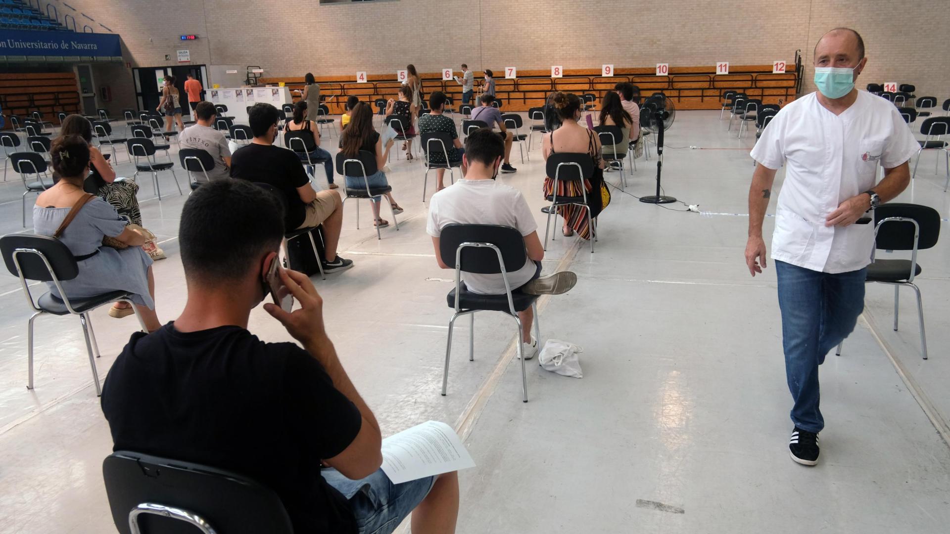 Varias personas esperan tras vacunarse en julio en el polideportivo de la UPNA