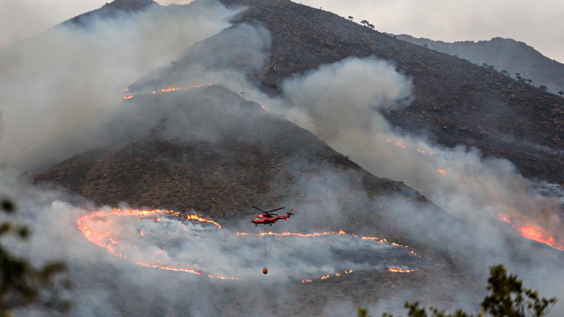 Un helicópetero trabaja en las labores de extinción del incendio de Sierra Bermeja