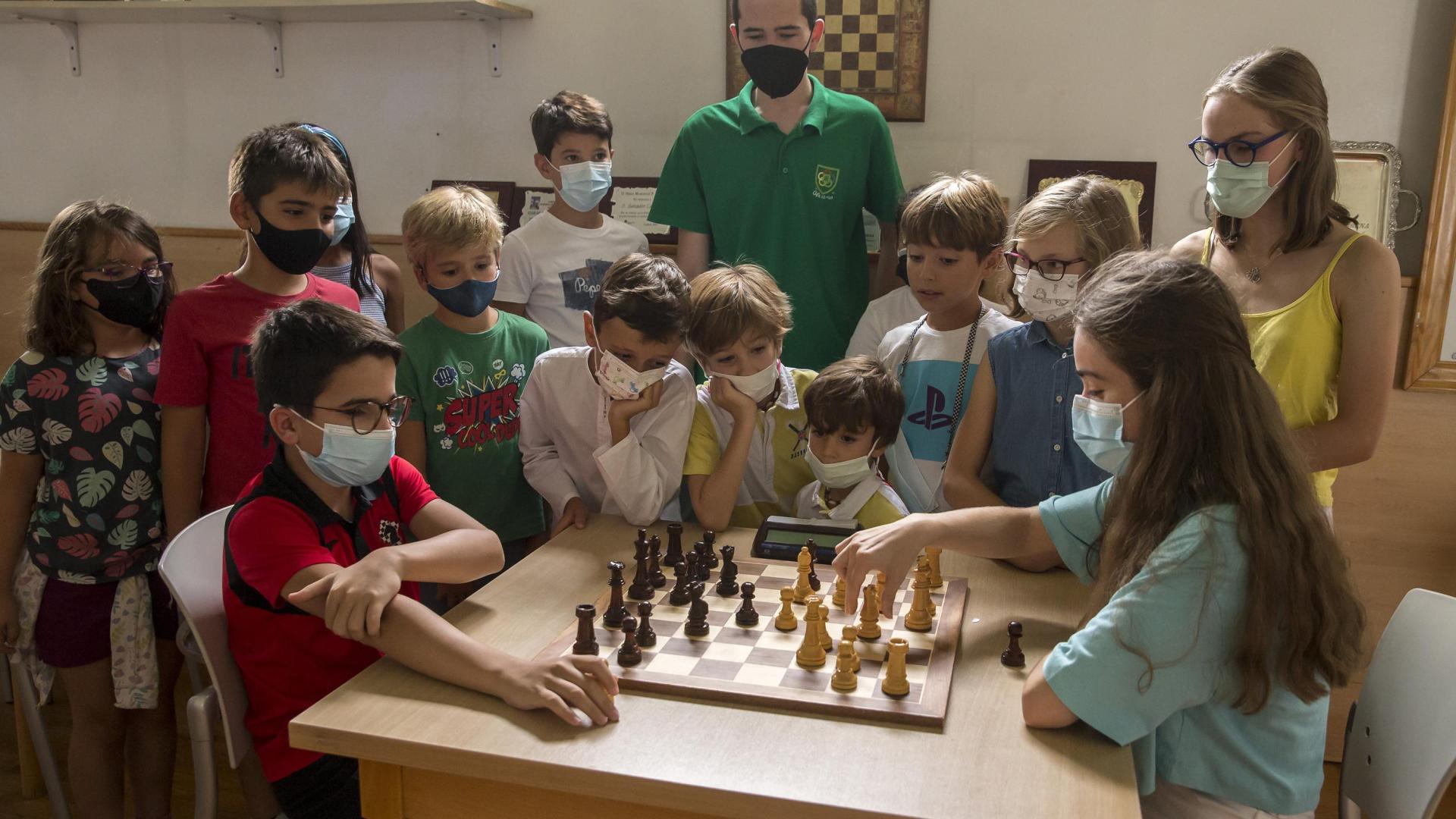 Javier Habans y Leyre Abarisqueta disputan una partida de ajedrez mientras sus compañeros de la escuela de ajedrez de Oberena miran