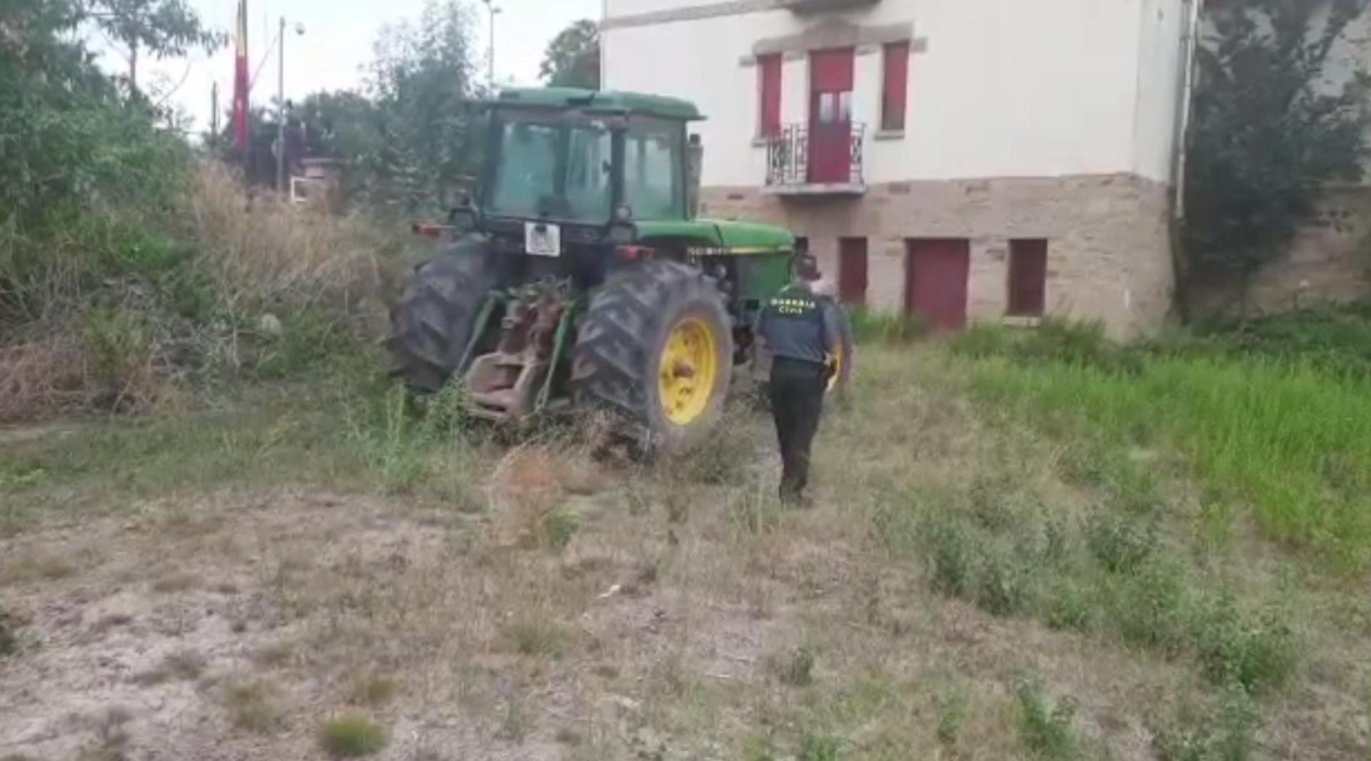Un agente de la Guardia Civil, junto al tractor sustraído.