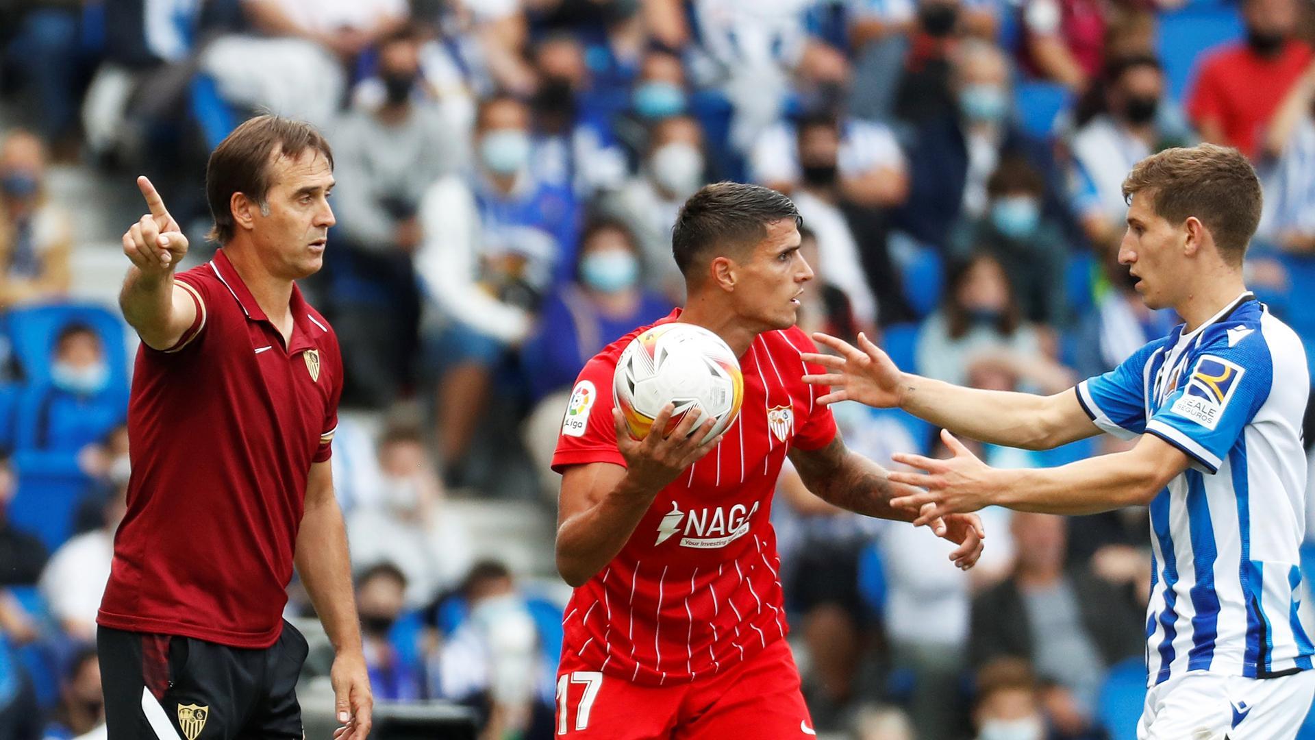 El técnico del Sevilla, Julen Lopetegui (izda.) gesticula ante su jugador, Erik Lamela que pugan por el balón con el realista Aihen Muñoz