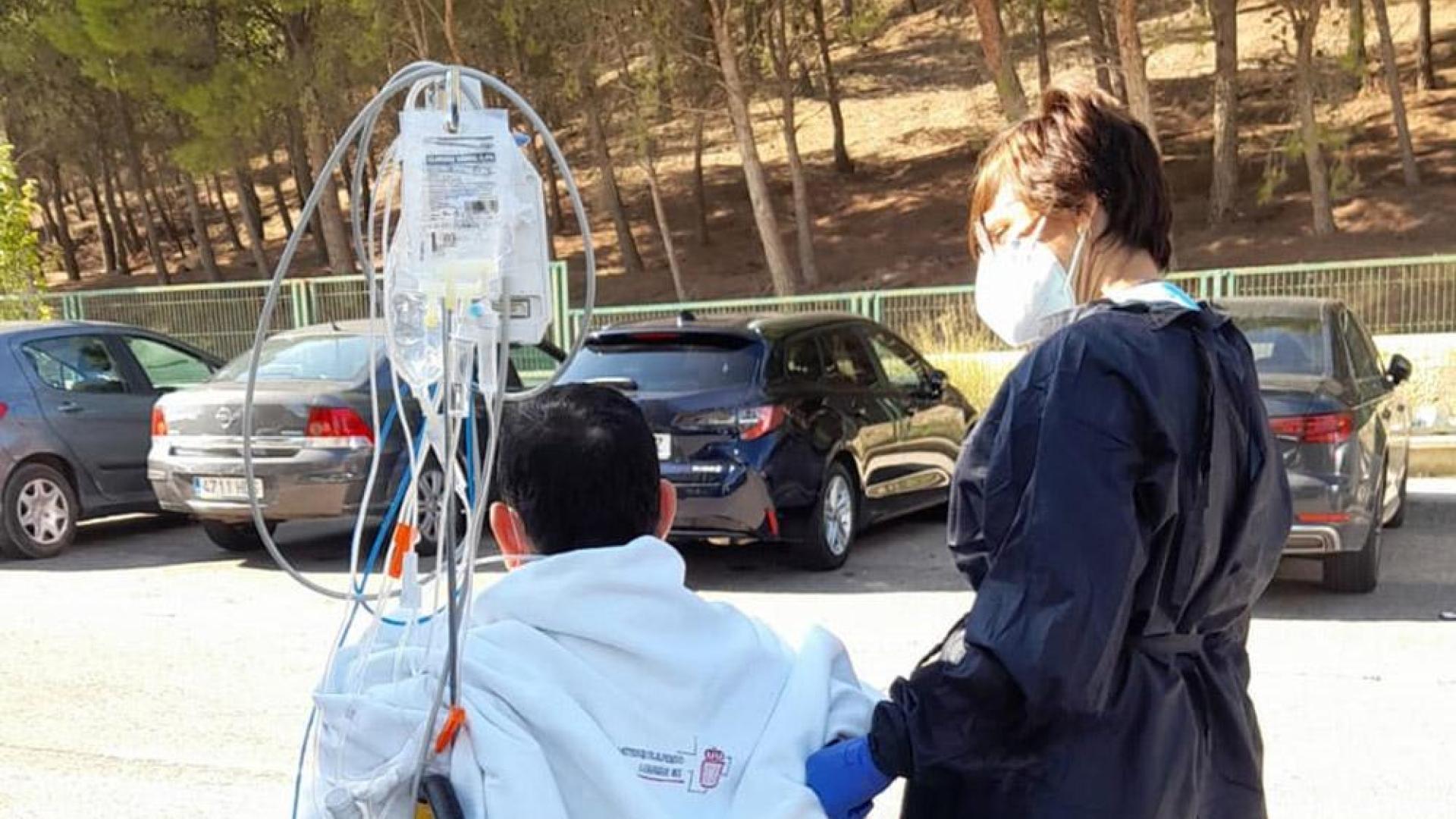 La enfermera Elena Torres, con el paciente, en el exterior del hospital