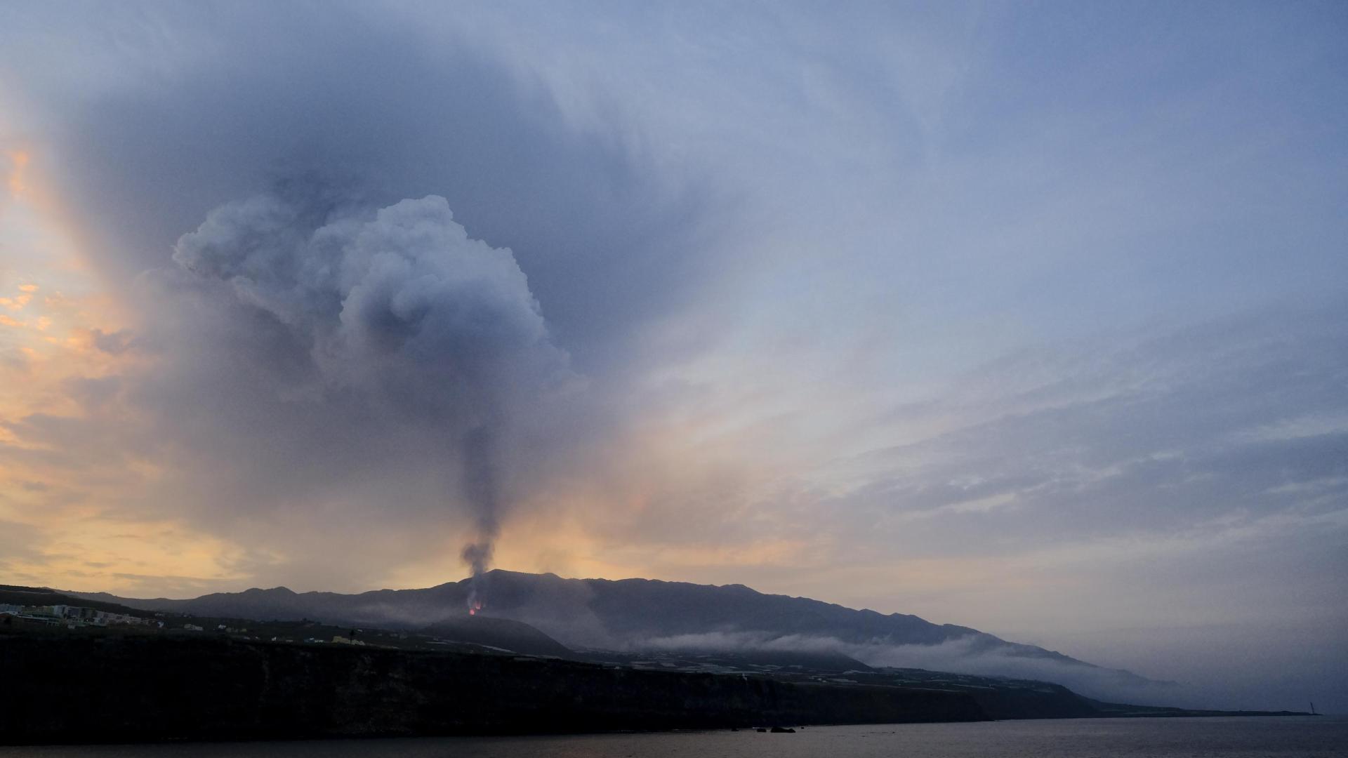 Columnas de humo y cenizas emergen del volcán en una imagen tomada este martes desde la localidad de Tazacorte, en la isla de La Palma