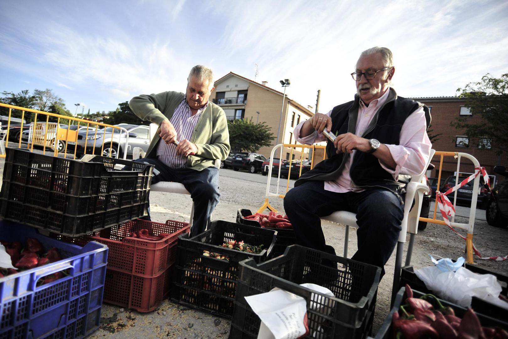 José Antonio Casanova (izda.) y Fernando Ona preparan los pimientos antes de asarlos