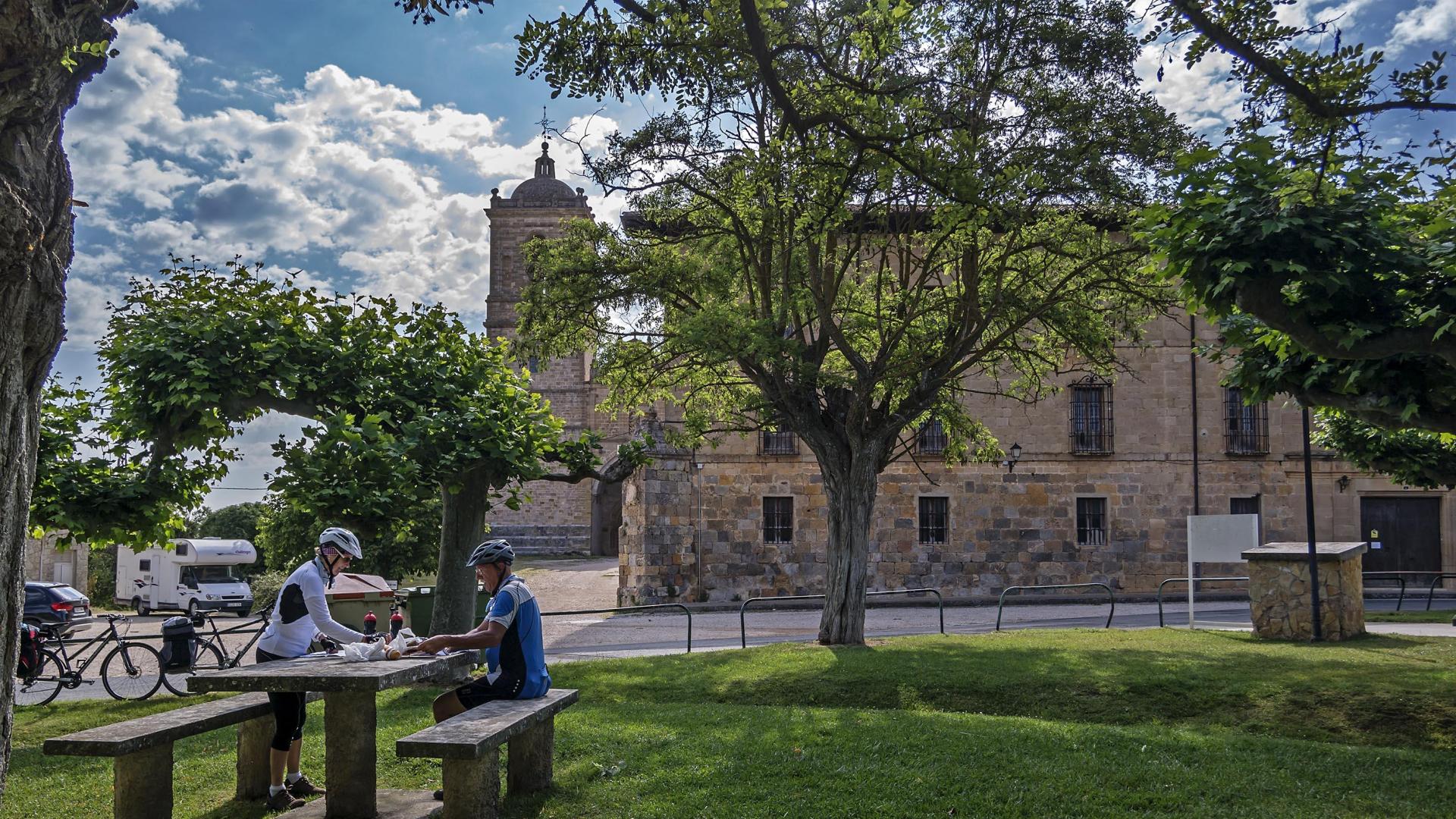 Dos ciclistas, en un merendero en el exterior del Monasterio de Irache