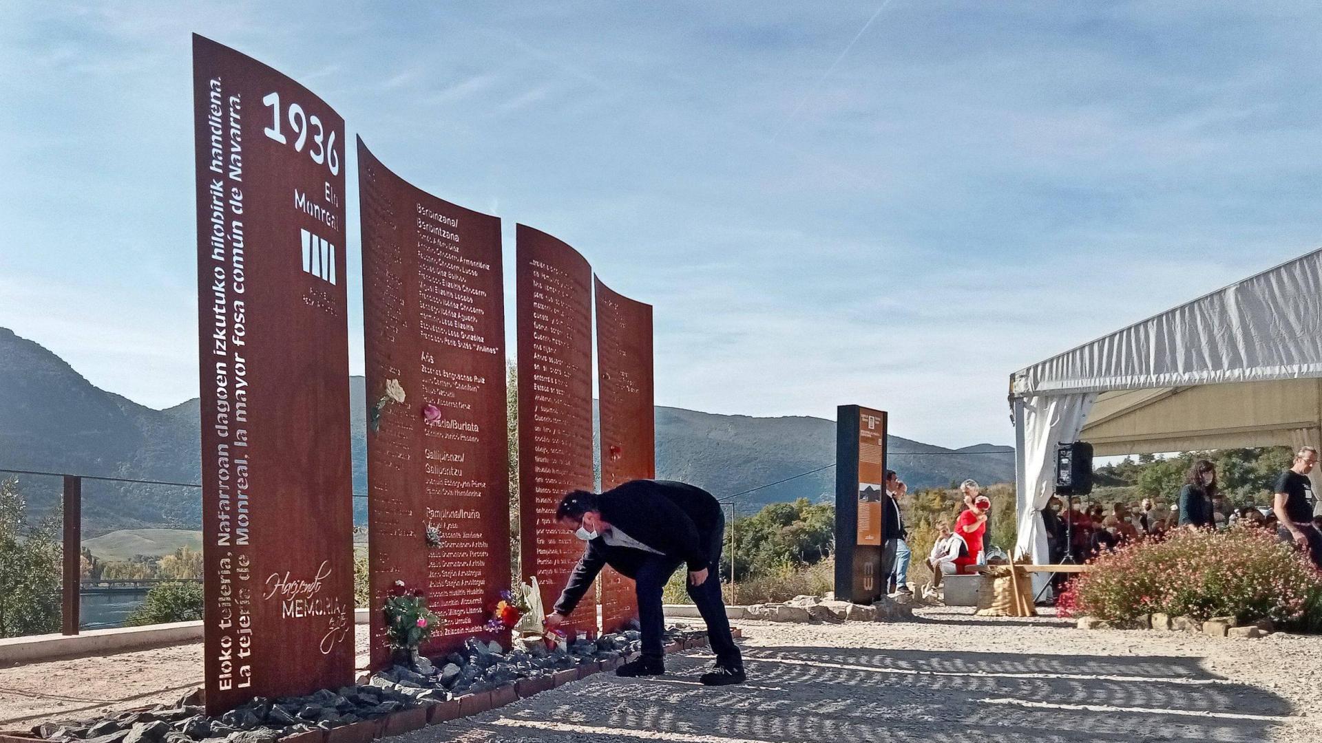 Un nieto de Aurelio León (alcalde de Aoiz fusilado en la tejería), depositando flores en el monolito