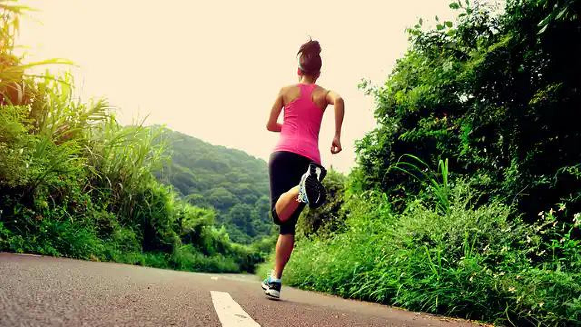 Una mujer, corriendo en una carretera