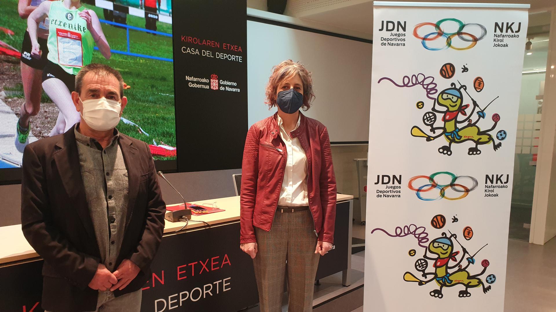 Primitivo Sánchez, subdirector del Instituto Navarro del Deporte y la consejera de Cultura y Deporte, Rebeca Esnaola, junto a un cartel con el logotipo y la mascota de los juegos