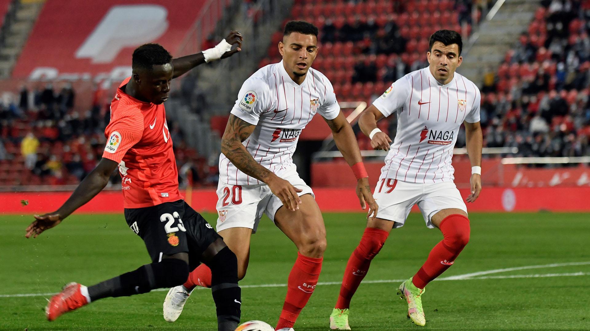 Los sevillistas Diego Carlos y Marcos Acuña disputan un balón a Ndiaye, del Mallorca, en el partido disputado este miércoles en Son Moix