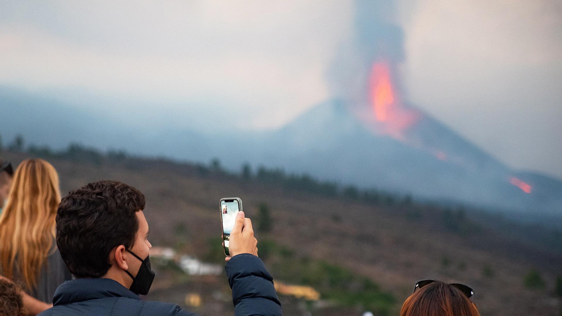 Varias personas y medios de comunicación en el mirador de Tajuya observando la erupción
