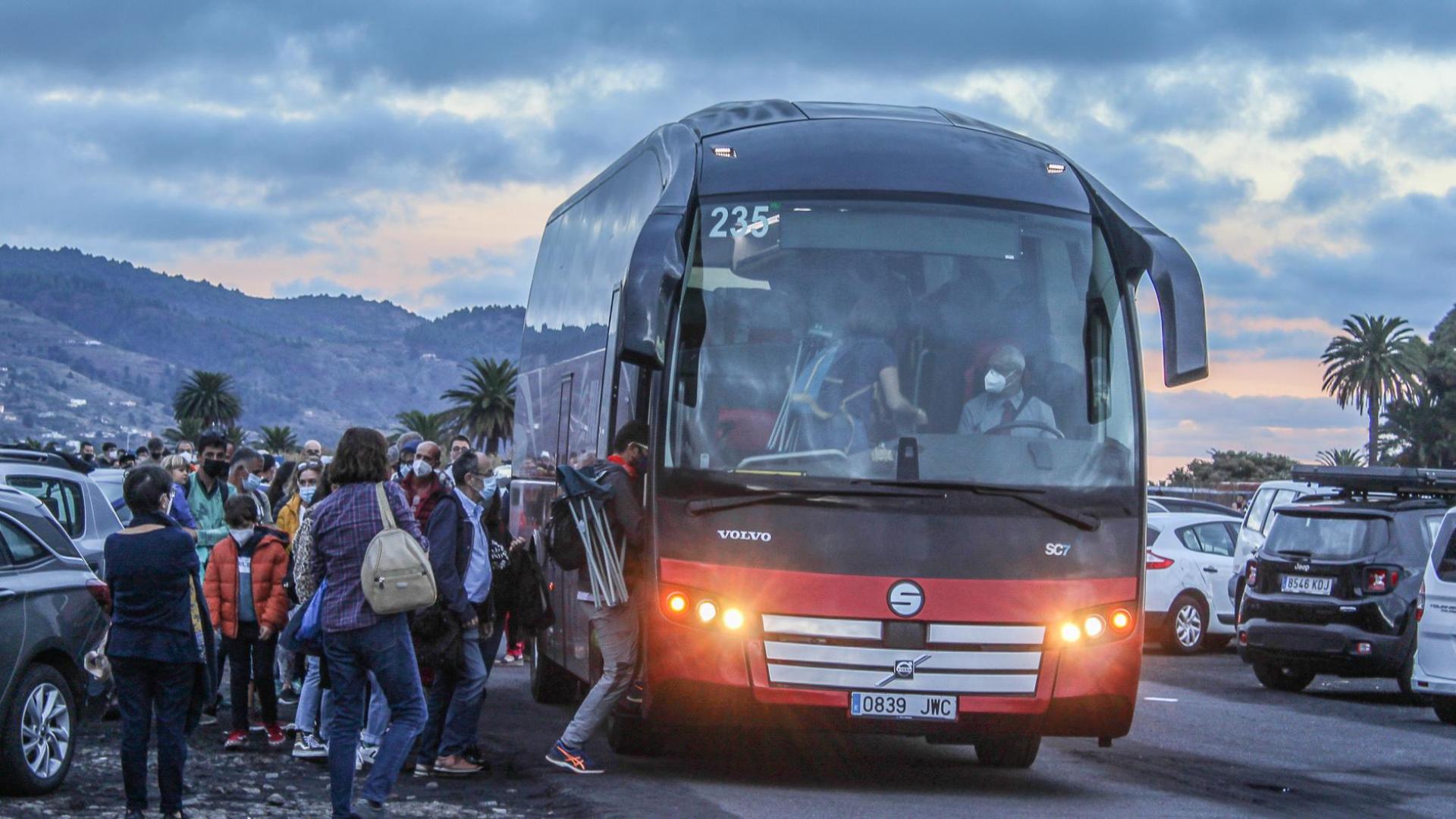 Cientos de personas se desplazan en los autobuses que las autoridades de La Palma han dispuesto para acceder hasta la zona del volcán