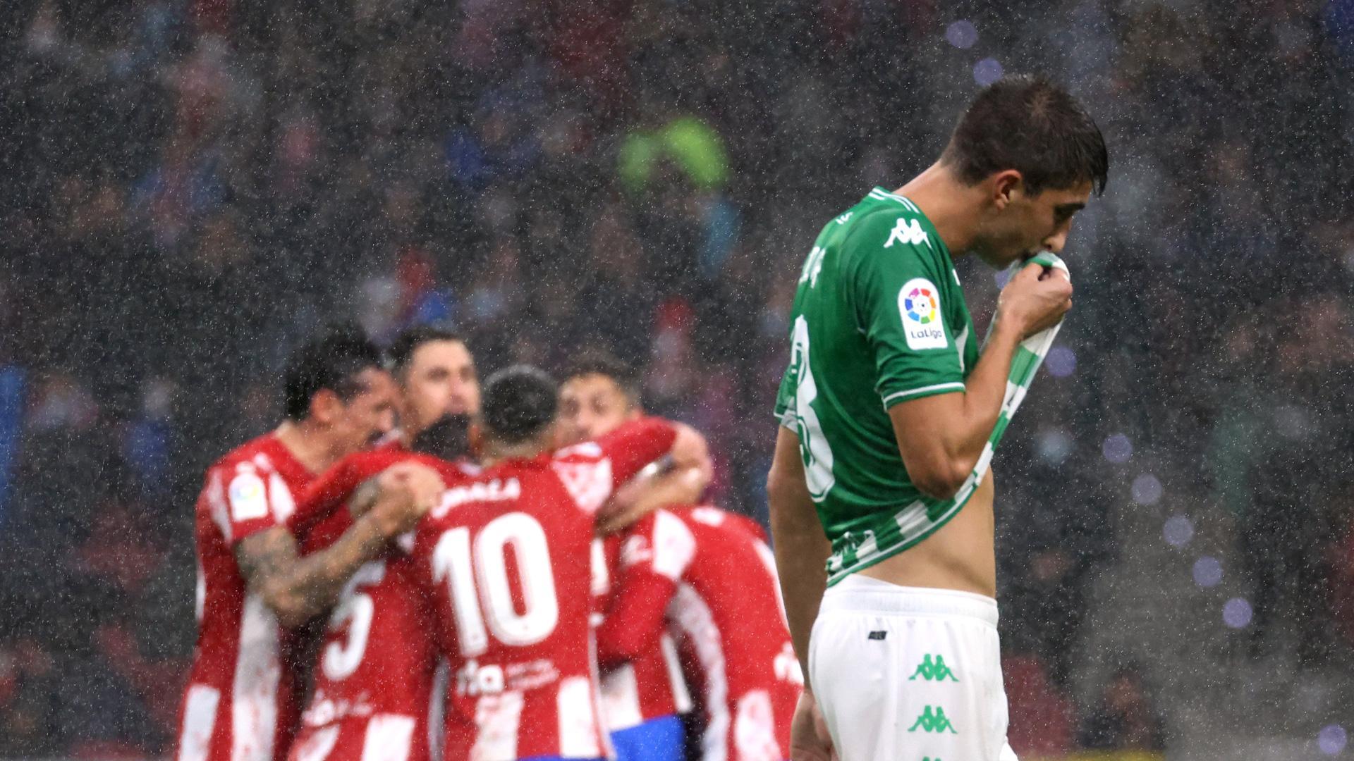 Los jugadores del Atlético de Madrid festejan el gol de Joao Felix delante del futbolista del Betis Edgar González